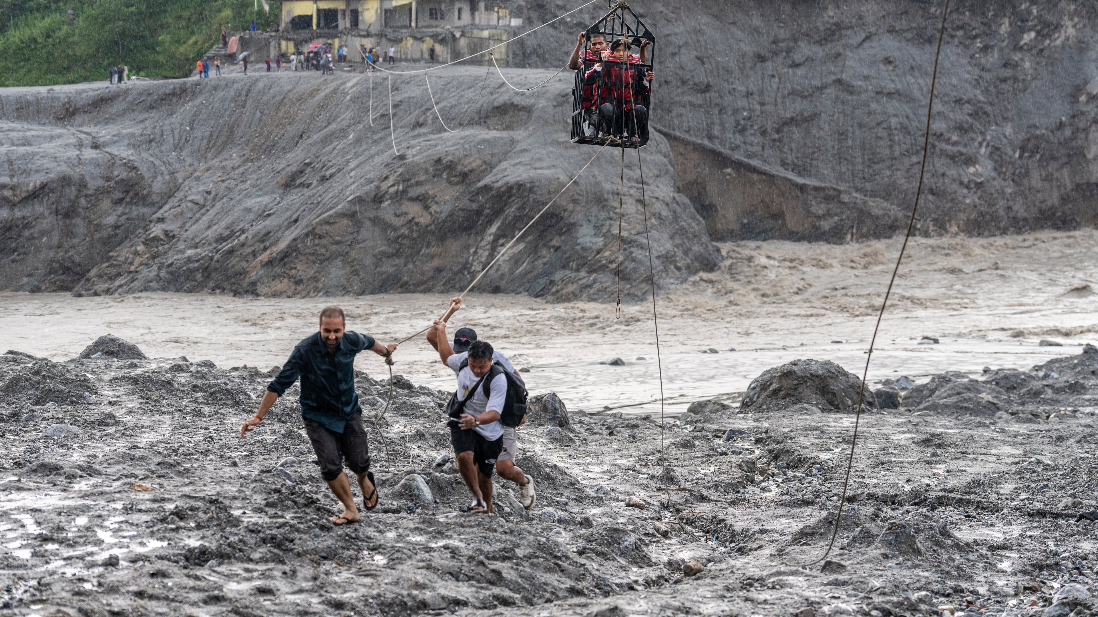 Residents pull a newly installed zipline to help people commute across the Trishuli river in the aftermath of flash floods at Bidur in Nepal's Nuwakot district, Nepal, Wednesday, Sept. 2, 2026. (AP Photo/Rajesh Kumar Singh)
