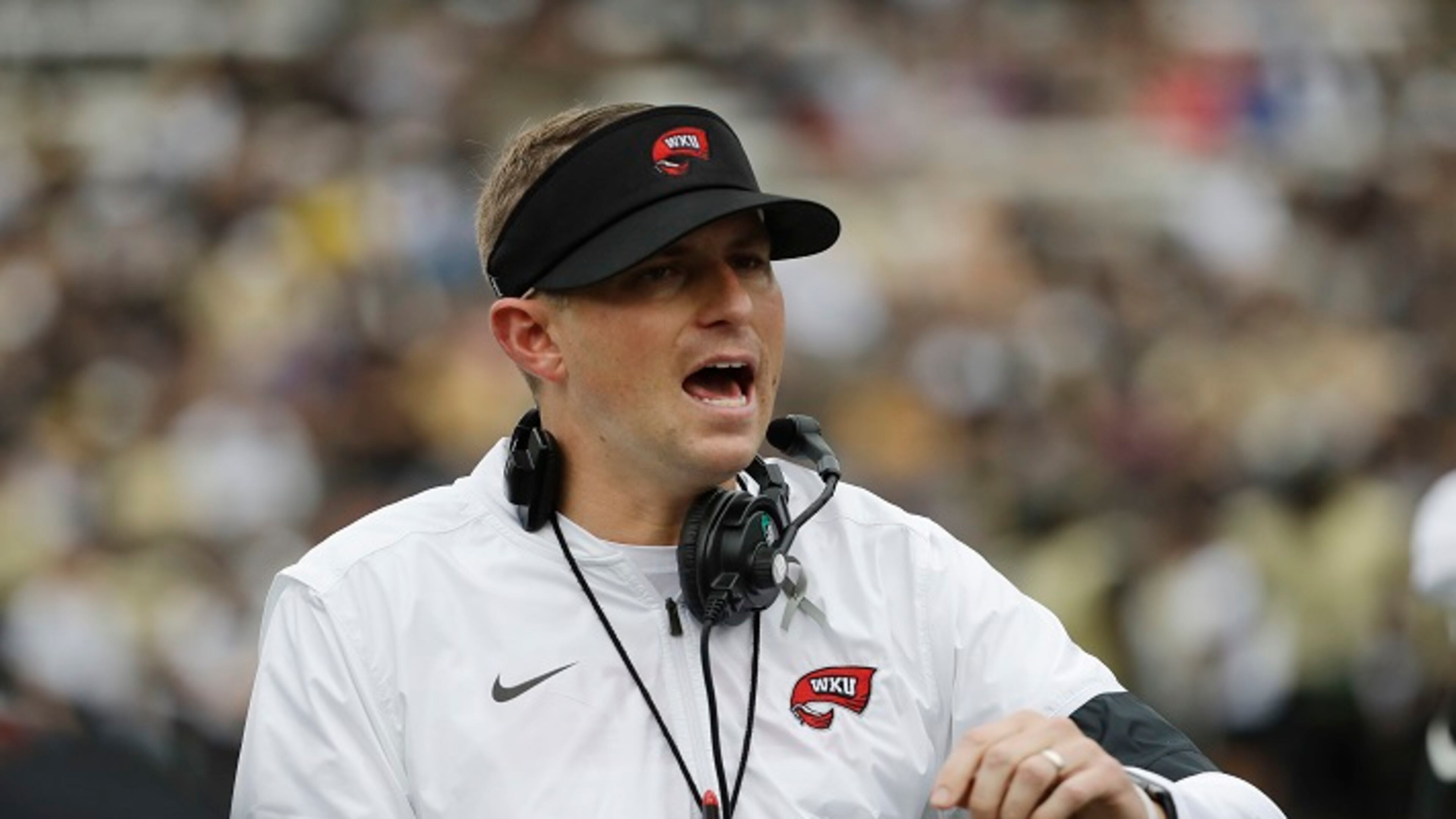 FILE - In this Nov. 4, 2017, file photo, Western Kentucky head coach Mike Sanford watches the action in the first half of an NCAA college football game against Vanderbilt, in Nashville, Tenn. When Alabama switched offensive coordinators during last seasonâs playoff, it had an in-house solution. The Crimson Tideâs support staff included former Washington and Southern California head coach Steve Sarkisian, who took over the offense for the championship game. Western Kentucky didnât have that luxury this season when offensive line coach Geoff Dart was diagnosed with brain tumors and underwent surgery to limit his availability. The Hilltoppers had to rely on tight ends coach Mike Mahaffey and graduate assistant Mike Bivin to pick up the slack. Those two examples underscore the difference in staff sizes between Power Five programs and Group of Five schools. (AP Photo/Mark Humphrey, File)