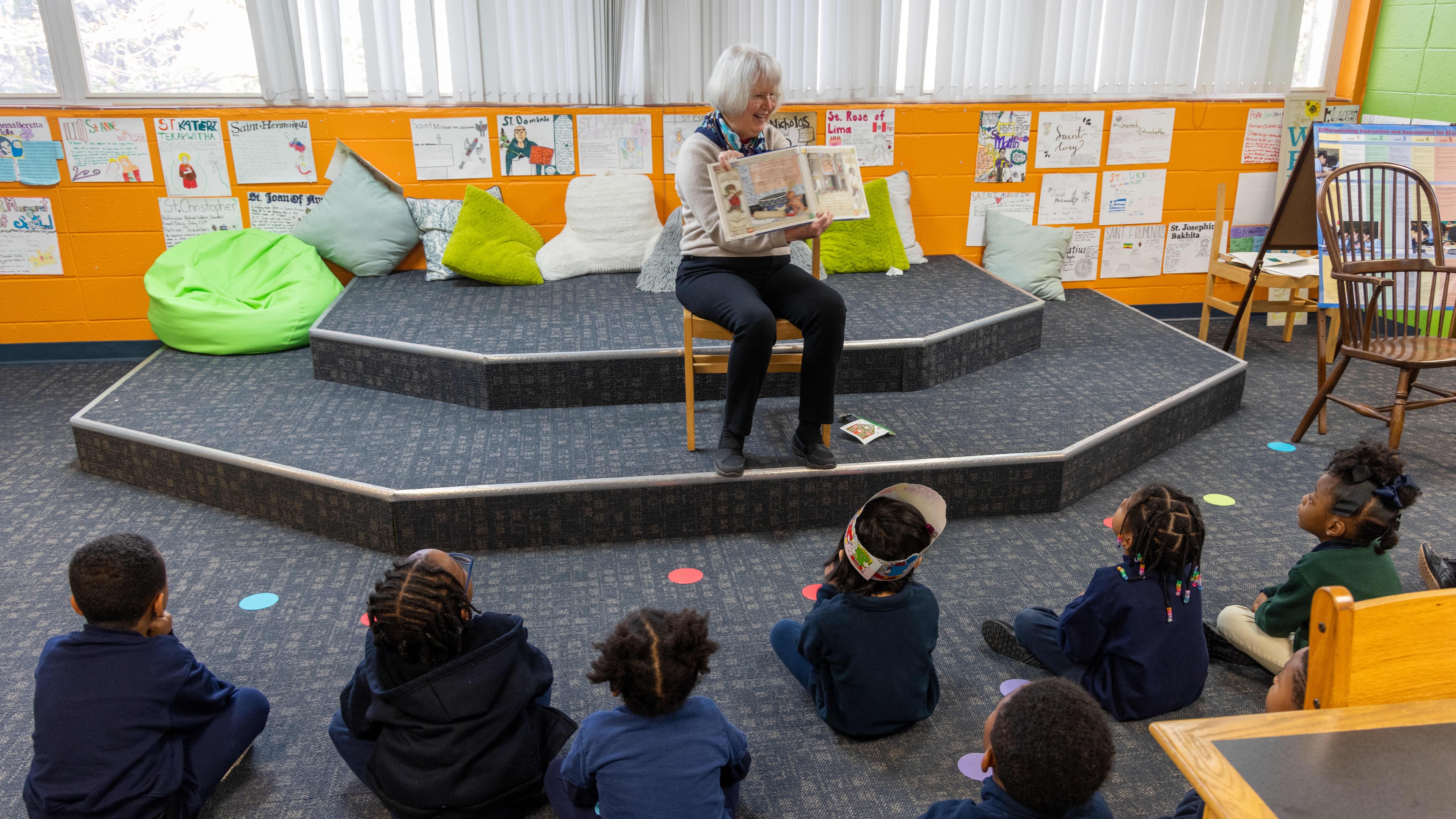Rosemary Schleicher reads a book to a group of pre-k and Kindergarten students in the Saint Peter Claver Regional Catholic School library. Volunteers with the nonprofit Christ Child Society help needy children in several ways. At Saint Peter Claver Regional Catholic School they tutor and support the students and staff. (Phil Skinner for the AJC)