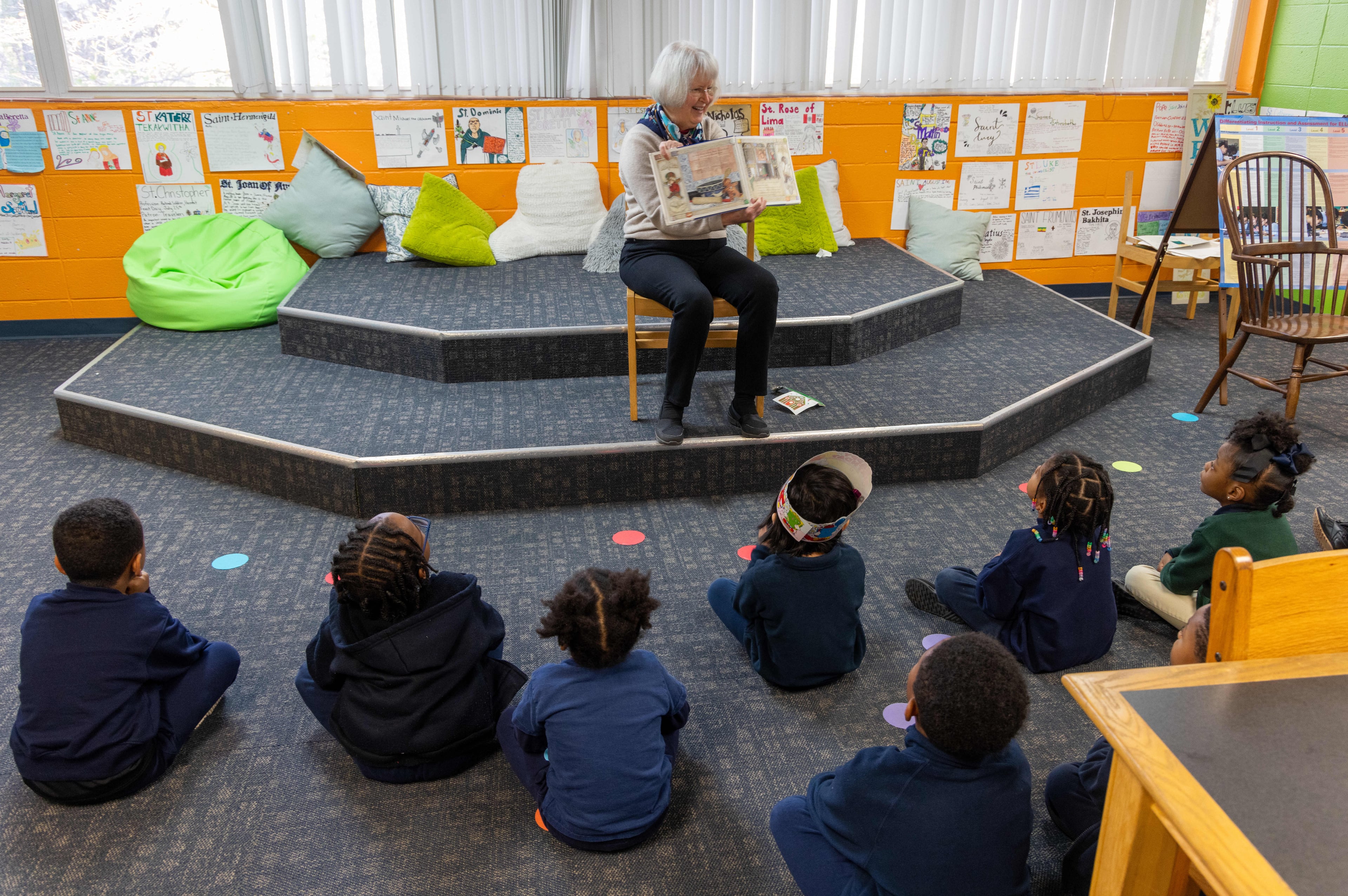 Rosemary Schleicher reads a book to a group of pre-k and Kindergarten students in the Saint Peter Claver Regional Catholic School library. Volunteers with the nonprofit Christ Child Society help needy children in several ways. At Saint Peter Claver Regional Catholic School they tutor and support the students and staff. (Phil Skinner for the AJC)