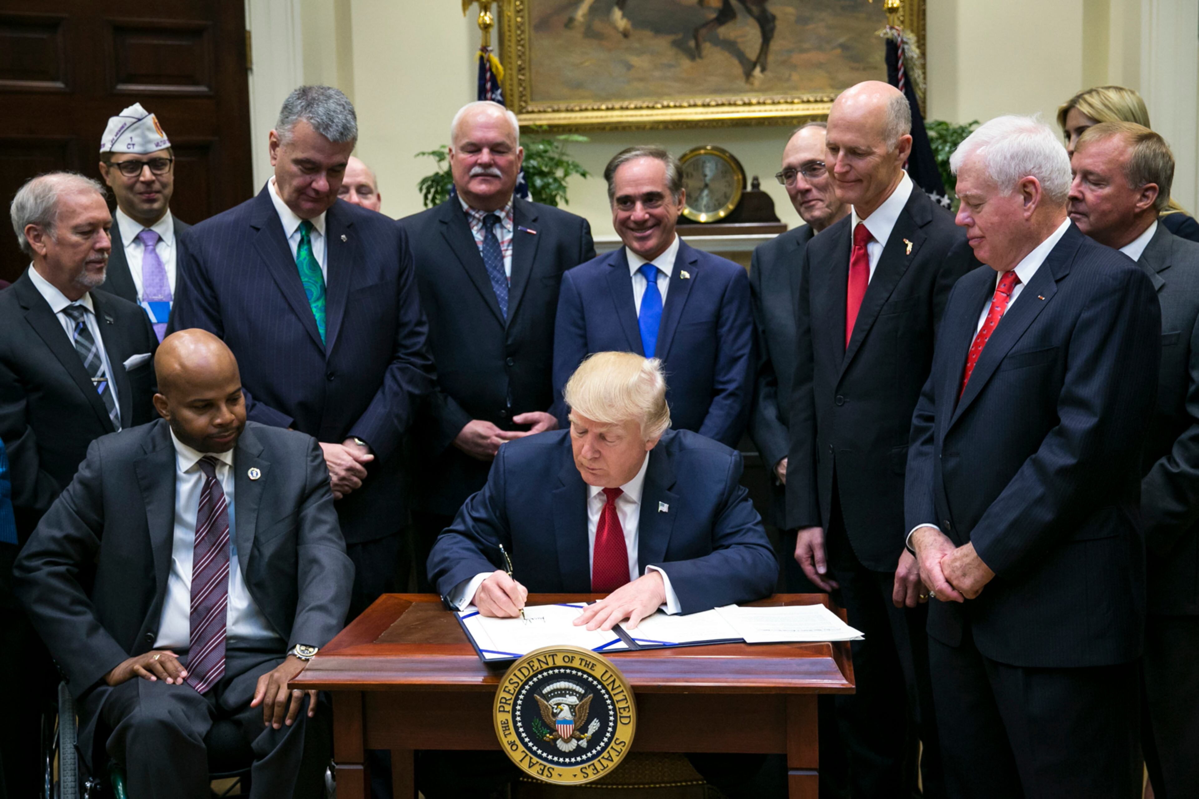 President Donald Trump signs a bill extending a program that allows some veterans to seek health care in the private sector, in the Roosevelt Room of the White House in Washington, April 19, 2017. (Al Drago/The New York Times)