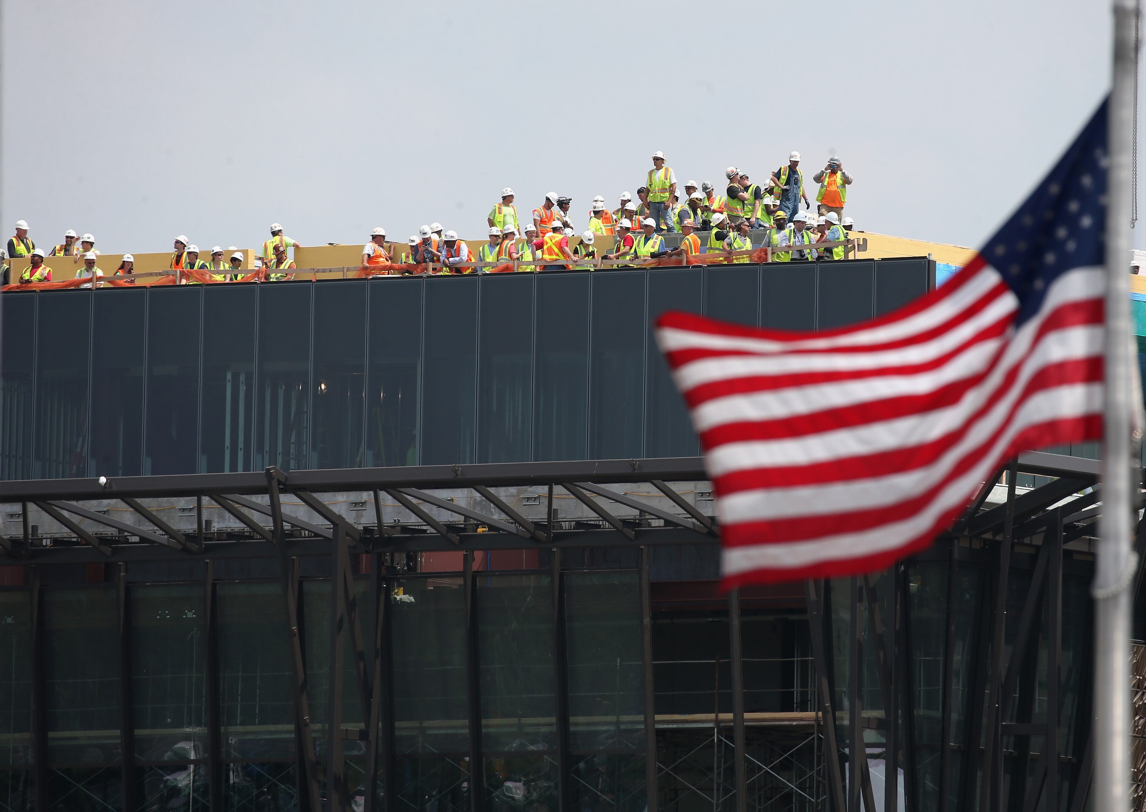 WASHINGTON, DC - MAY 08: Workers stop work and gather on the roof of the new National Museum of African American History to watch vintage World War II war planes fly down the National Mall May 8, 2015 in Washington, DC. Fifty six vintage war planes took part in a flyover near the WWII memorial for the 70th anniversary Victory in Europe celebration. (Photo by Mark Wilson/Getty Images)