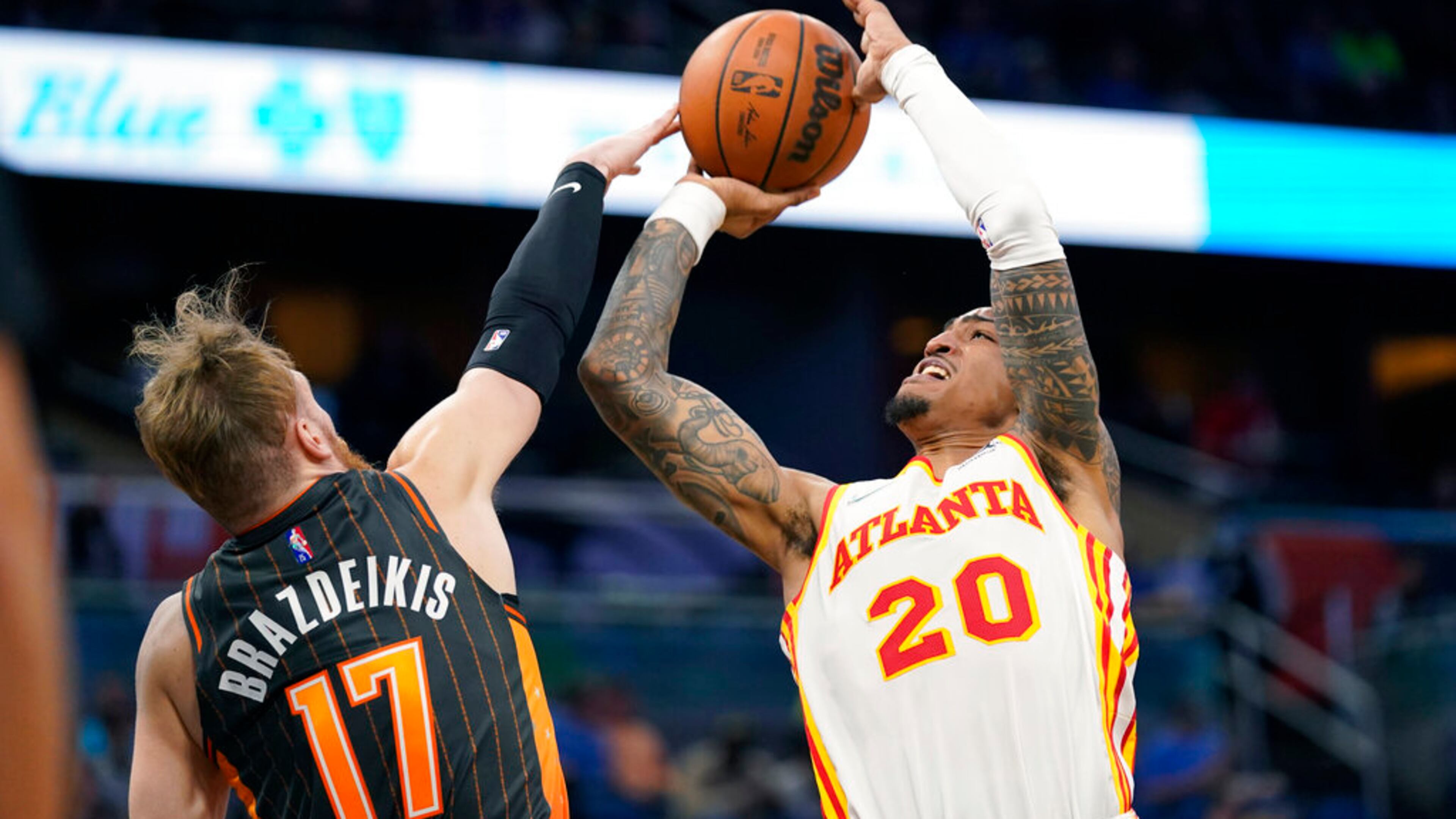 Orlando Magic forward Ignas Brazdeikis (17) blocks a shot by Atlanta Hawks forward John Collins (20) during the first half of an NBA basketball game, Wednesday, Dec. 15, 2021, in Orlando, Fla. (AP Photo/John Raoux)