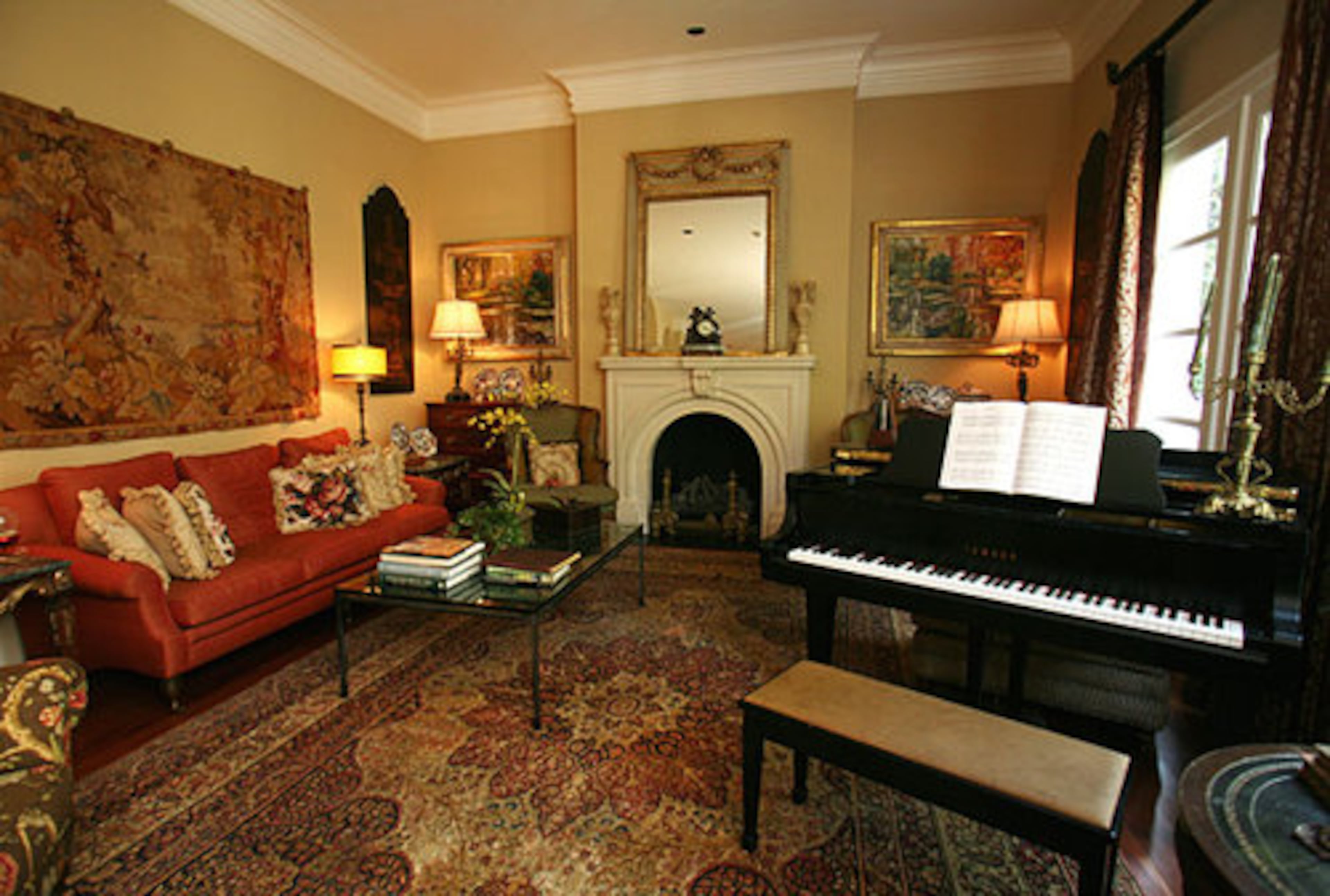 Opposite the dining room, the living room is anchored by a baby grand piano and a stone fireplace following the arch motif. Here, antiques mix comfortably with more contemporary pieces to preserve the room's touchable qualities. With three children, the Bartons wanted an environment that could take a few bumps and sticky fingers in stride.