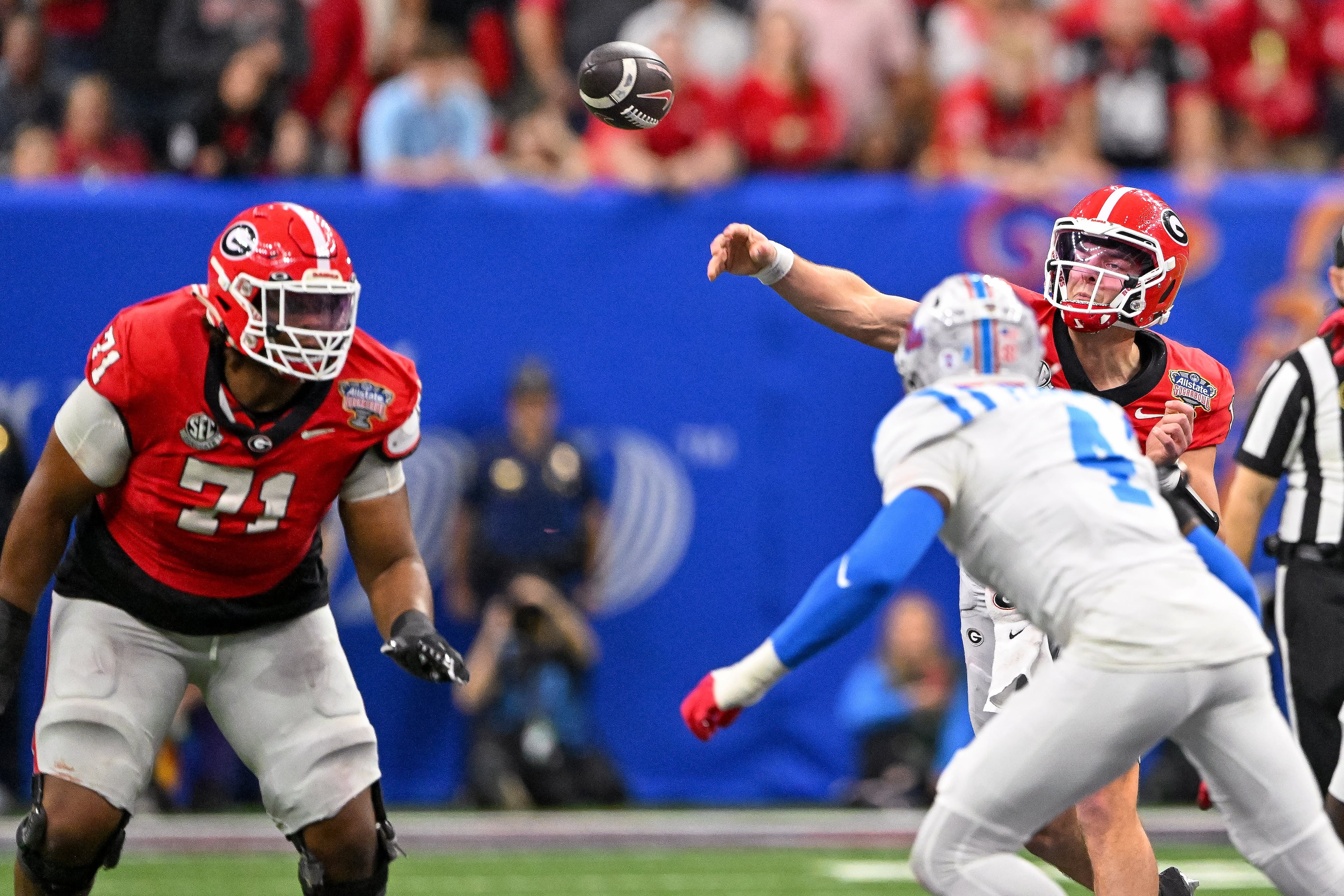 Georgia Bulldogs quarterback Gunner Stockton (14) throws a pass under pressure fr4om Ole Miss Rebels linebacker Suntarine Perkins (4) during the third quarter of the College Football Playoff quarterfinal game at the Sugar Bowl in the Caesars Superdome, Thursday, Jan. 1, 2026, in New Orleans. (Jason Getz/AJC)
