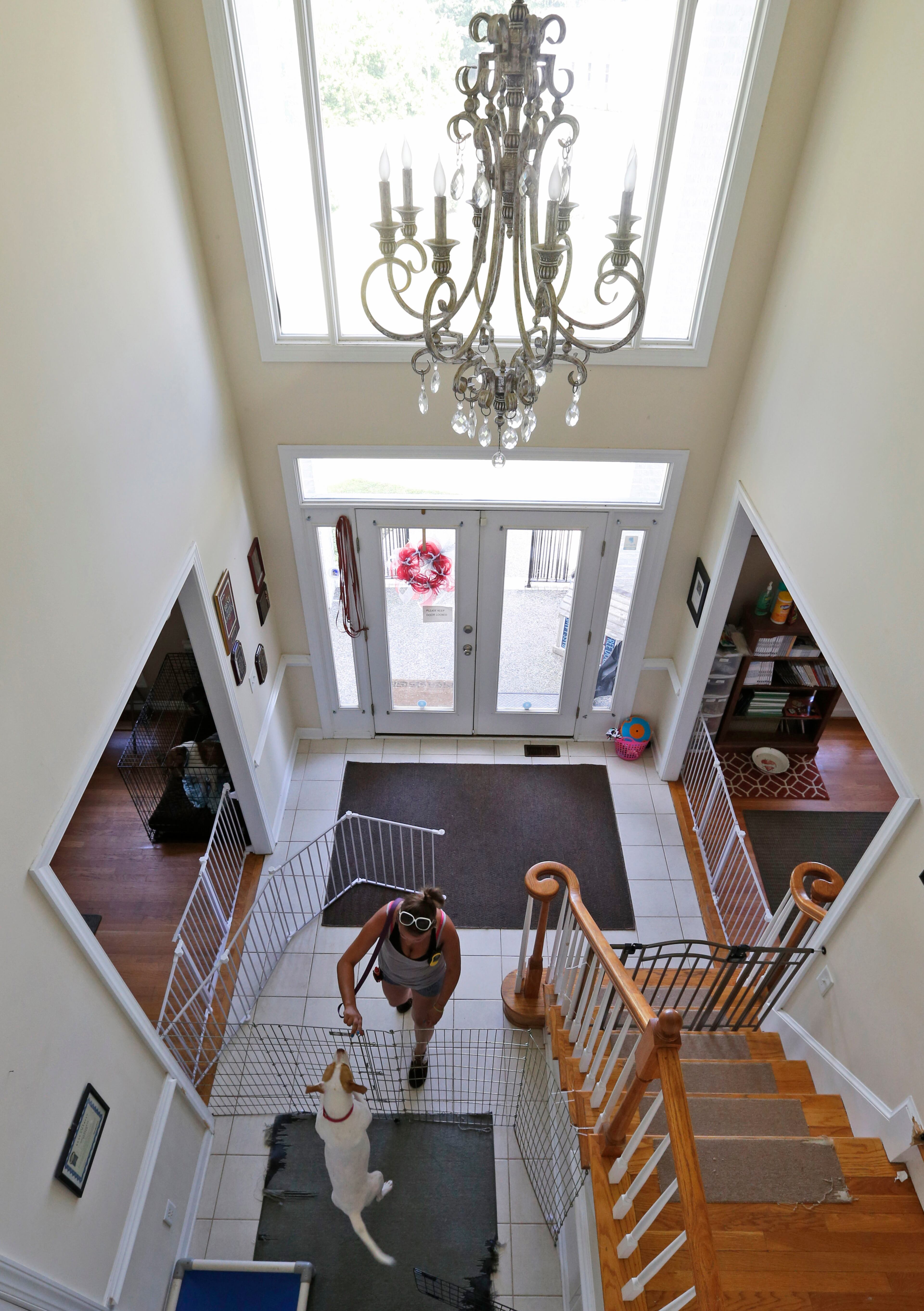 In this June 15, 2015, photo, caretaker Chrissy Appel, works with a dog in front entrance of the Good News Rehab Center, the former home of NFL football quarterback Michael Vick's Bad Newz Kennel in Smithfield, Va. The former Atlanta Falcons star quarterback served an 18-month federal prison sentence for running a dogfighting ring. (AP Photo/Steve Helber)