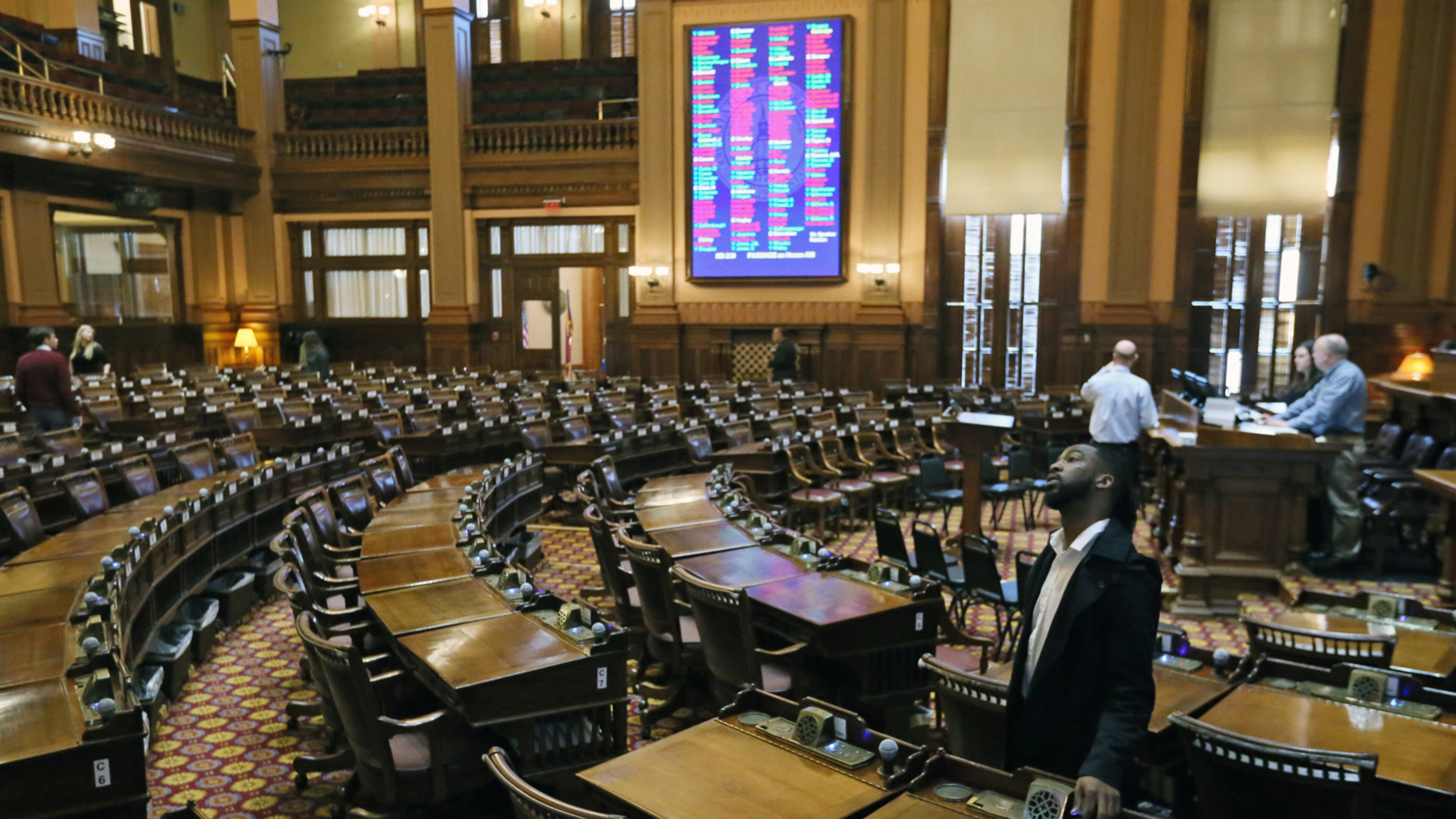 Members of the House Clerk's office staff test voting equipment in the House chamber. BOB ANDRES /BANDRES@AJC.COM