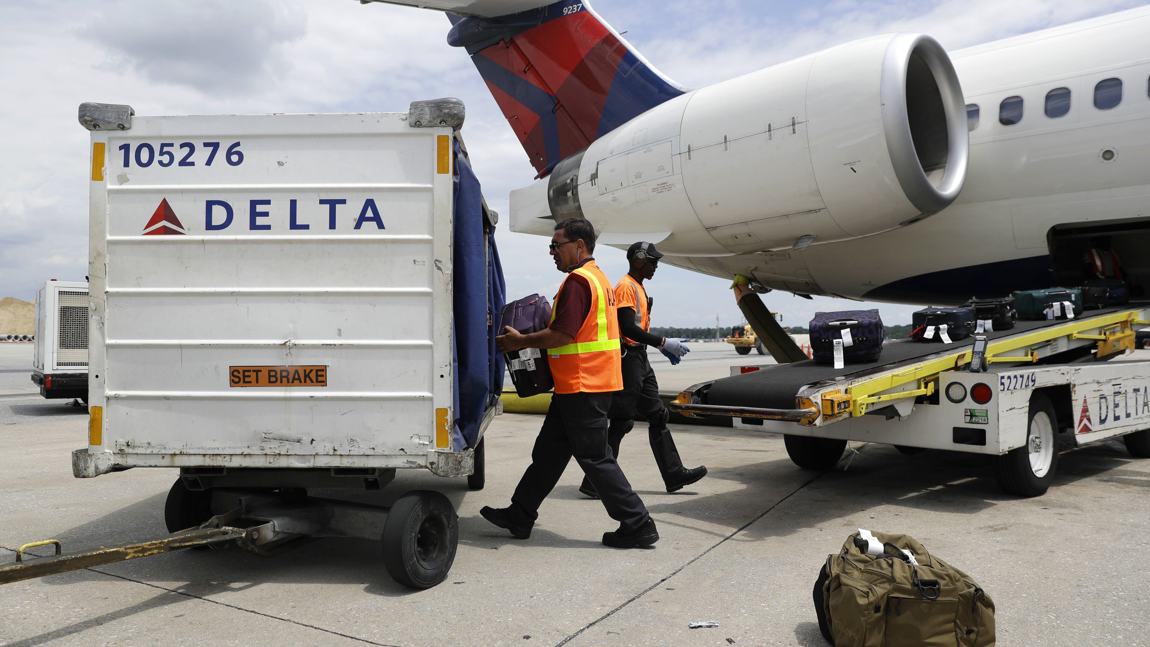 In this July 12, 2016, file photo, workers unload baggage from a Delta Air Lines flight at Baltimore-Washington International Thurgood Marshall Airport in Linthicum, Md. On Tuesday, Jan. 17, 2017, the federal Department of Transportation reported that U.S. airlines are improving on-time arrivals and canceling fewer flights. Hawaiian Airlines and Delta Air Lines posted the best rates for on-time arrivals. (AP Photo/Patrick Semansky, File)