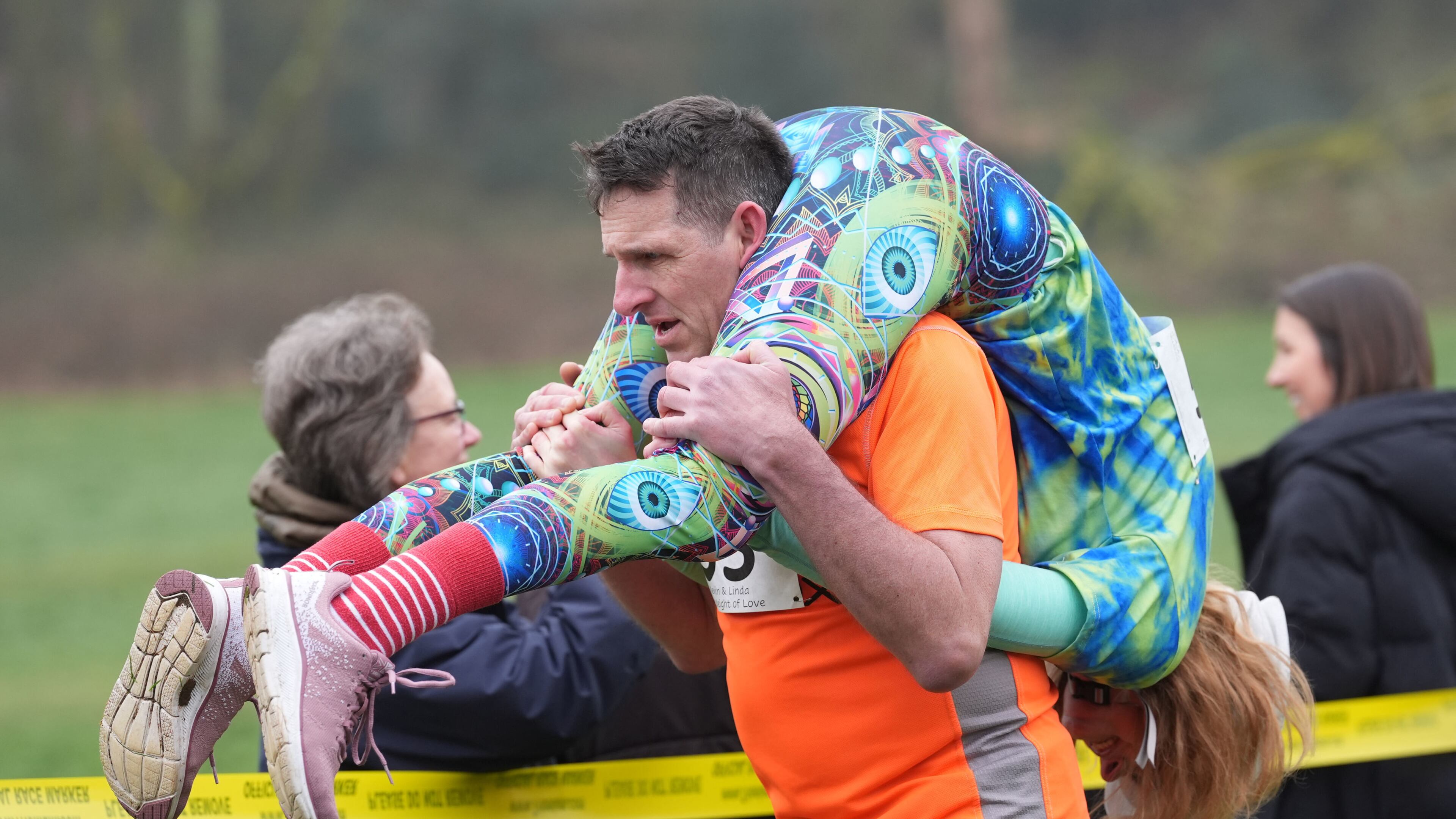 People take part in the annual UK Wife Carrying Race in Dorking, England, Sunday March 8, 2026. (Gareth Fuller/PA via AP)