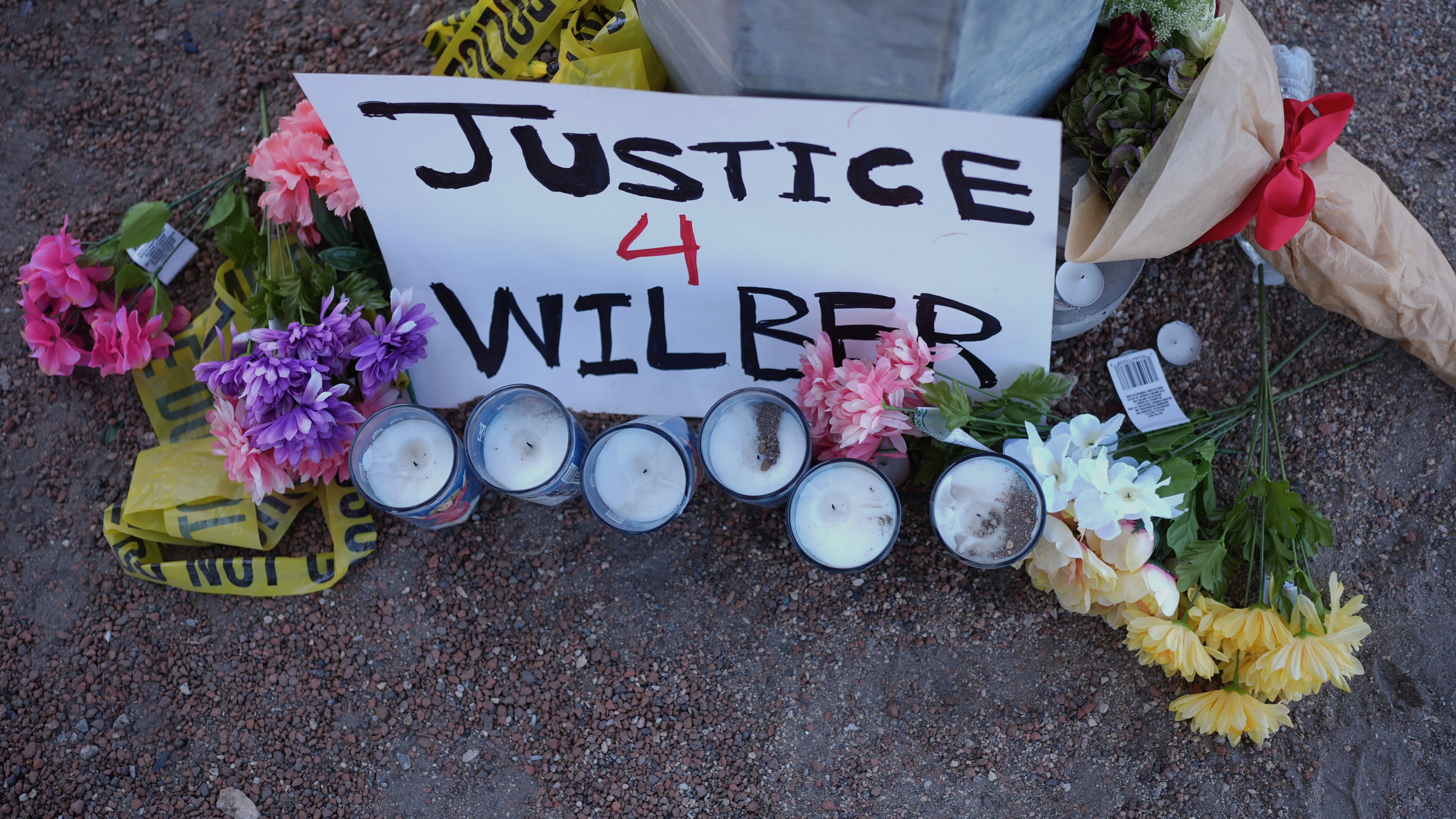 Flowers and candles are placed near the site where a Venezuelan man was shot in his vehicle by an ICE officer in Austin, Texas, Monday, Sept. 21, 2026. (AP Photo/Eric Gay)