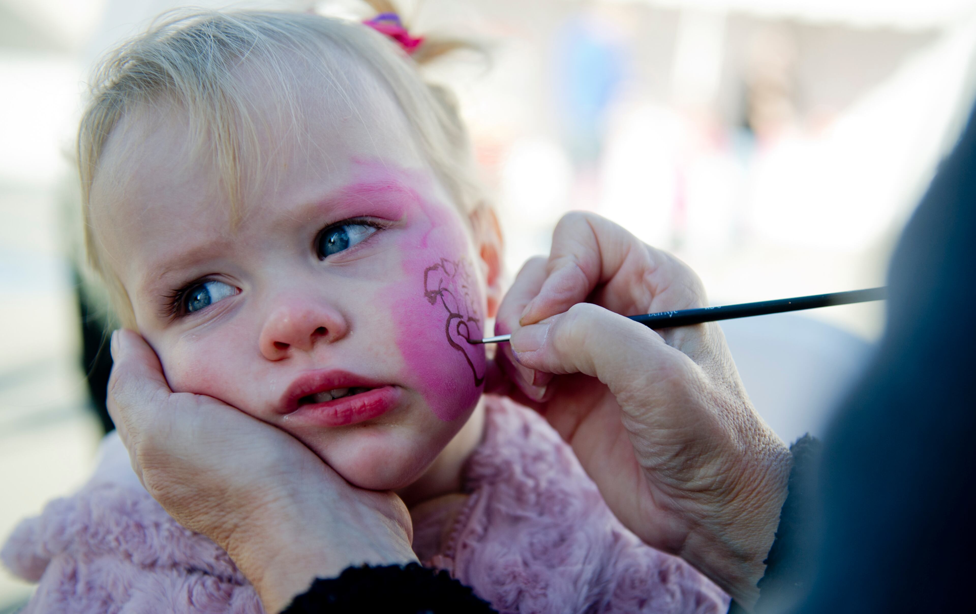 Eliana Spencer has her face painted with Priscilla the Pink Pig before going on the ride at Lenox Square Mall in Buckhead on Nov. 2, 2013.