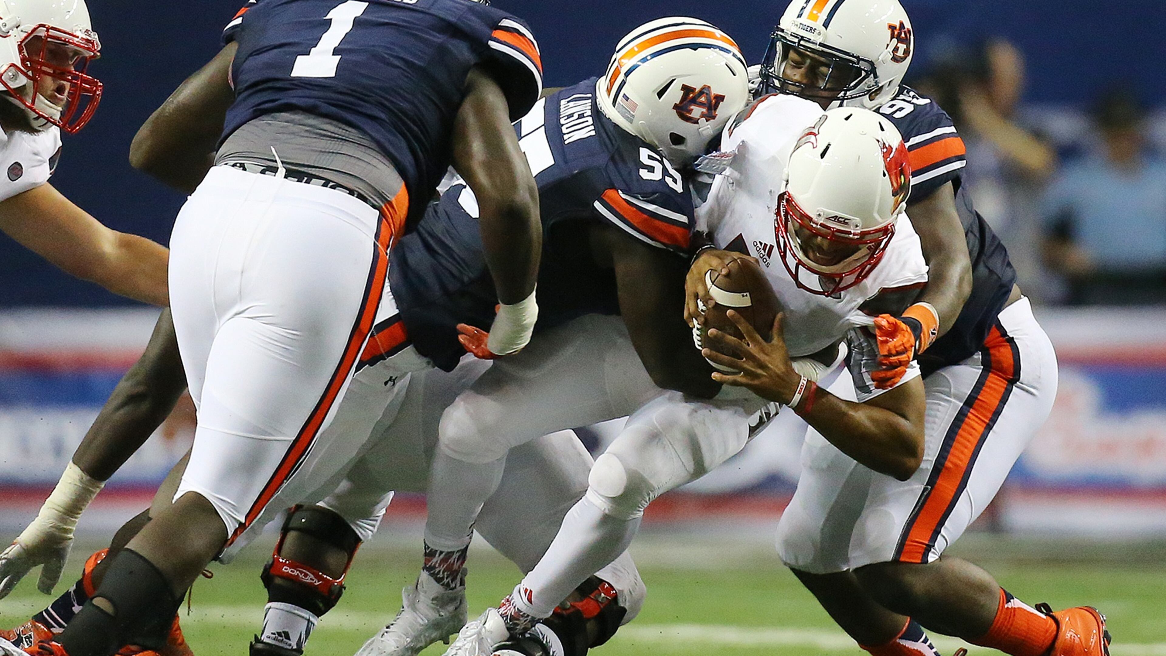 090515 ATLANTA: Louisville quarterback Reggie Bonnafon is sacked by Auburn defenders Carl Lawson (center) and Dontavius Russell (right) during the second quarter in the Chick-fil-A Kickoff Game on Saturday, Sept. 5, 2015, in Atlanta. Curtis Compton / ccompton@ajc.com