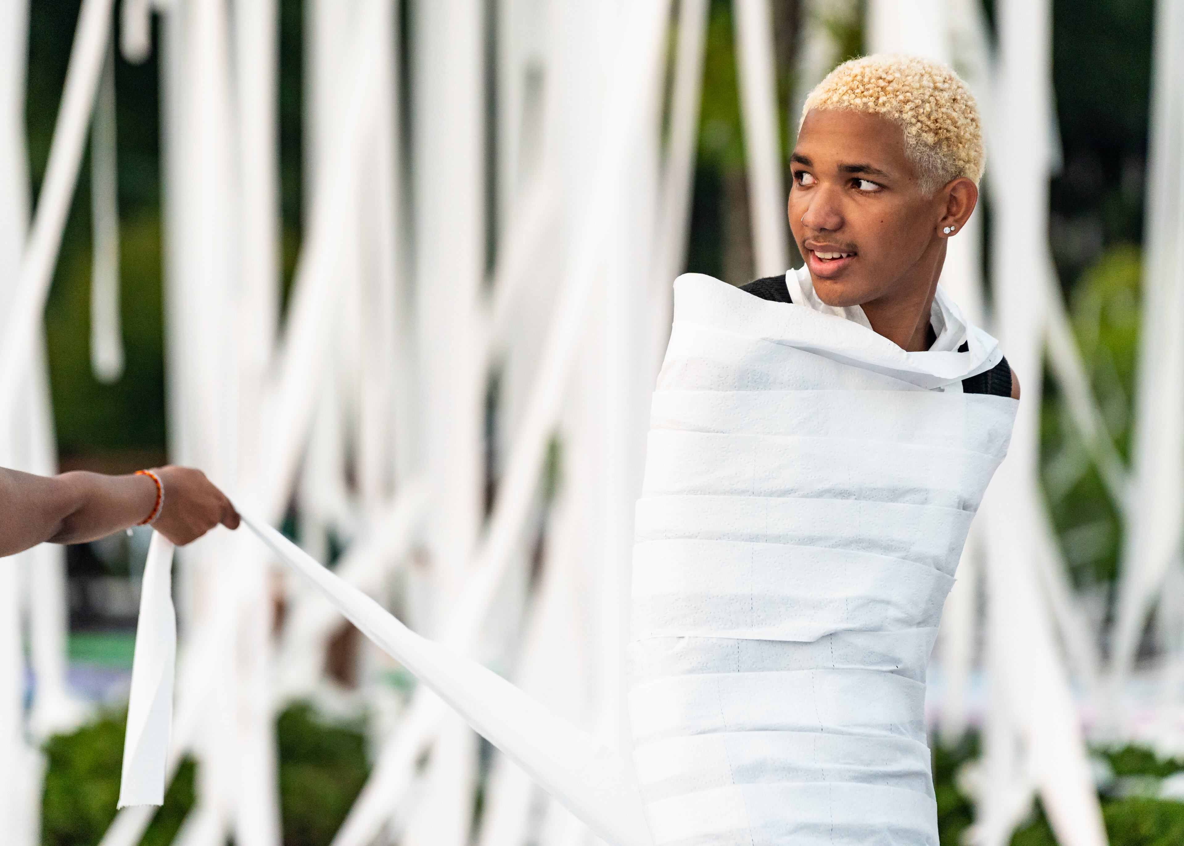 Incoming senior Jayden Coleman stands wrapped in toilet paper in the parking lot at Marietta High School in Marietta on Wednesday, July 31, 2024. (Seeger Gray / AJC)