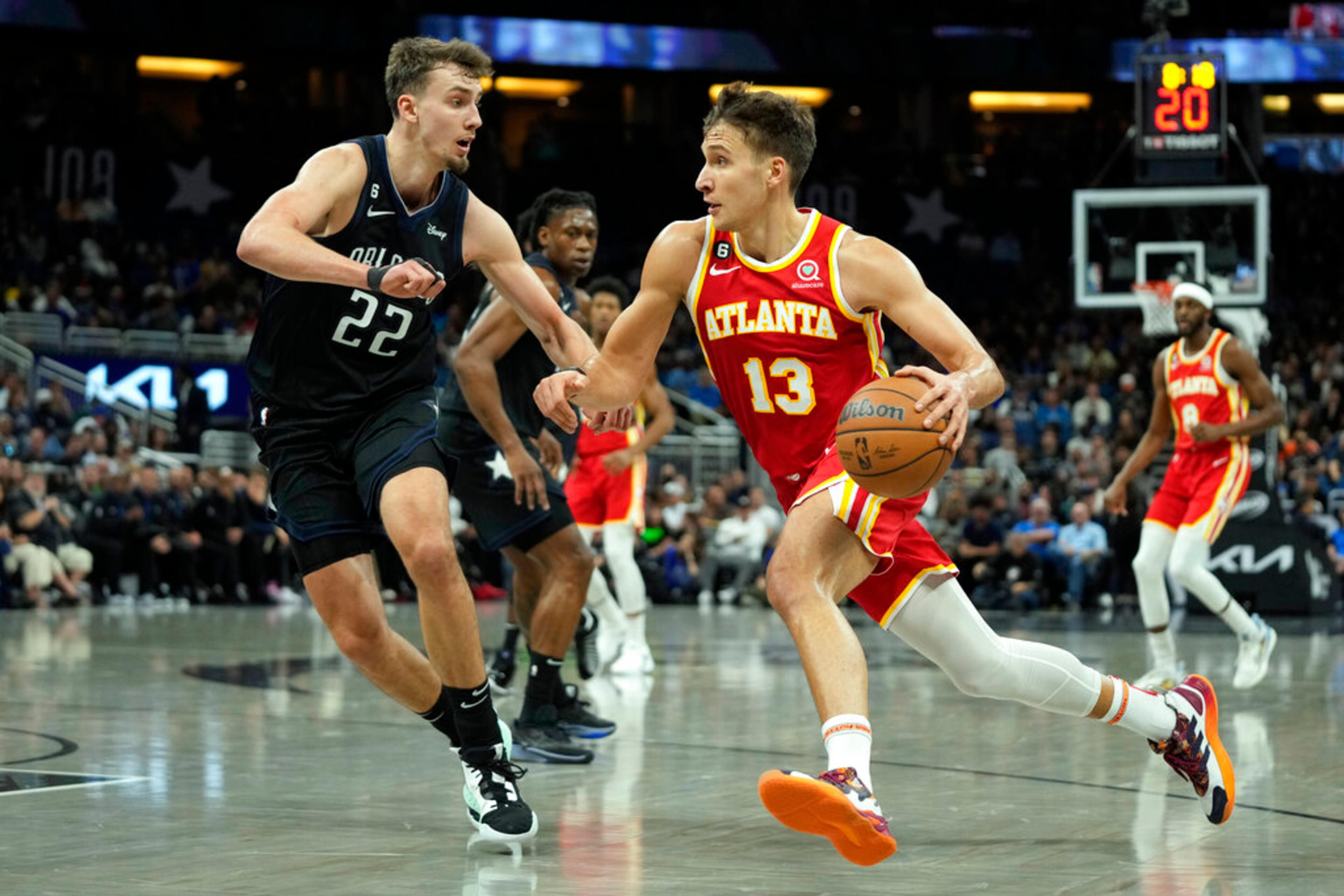 Atlanta Hawks' Bogdan Bogdanovic (13) moves to get past Orlando Magic's Franz Wagner (22) during the first half of an NBA basketball game, Wednesday, Dec. 14, 2022, in Orlando, Fla. (AP Photo/John Raoux)