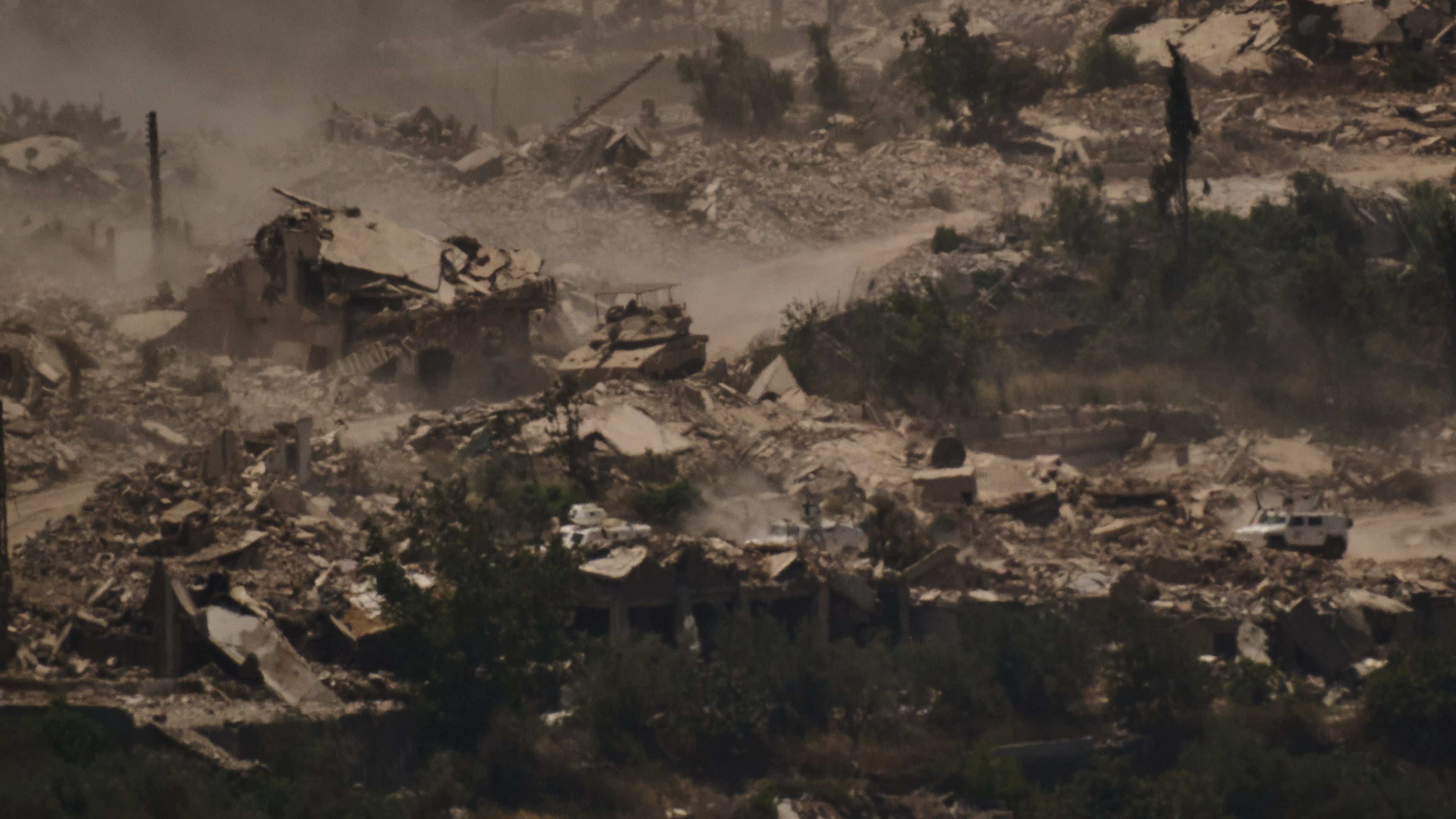 FILE - An Israeli tank moves past a convoy of the United Nations peacekeeping forces in Lebanon (UNIFIL) in southern Lebanon, as seen from northern Israel on June 26, 2026. (AP Photo/Leo Correa, File)