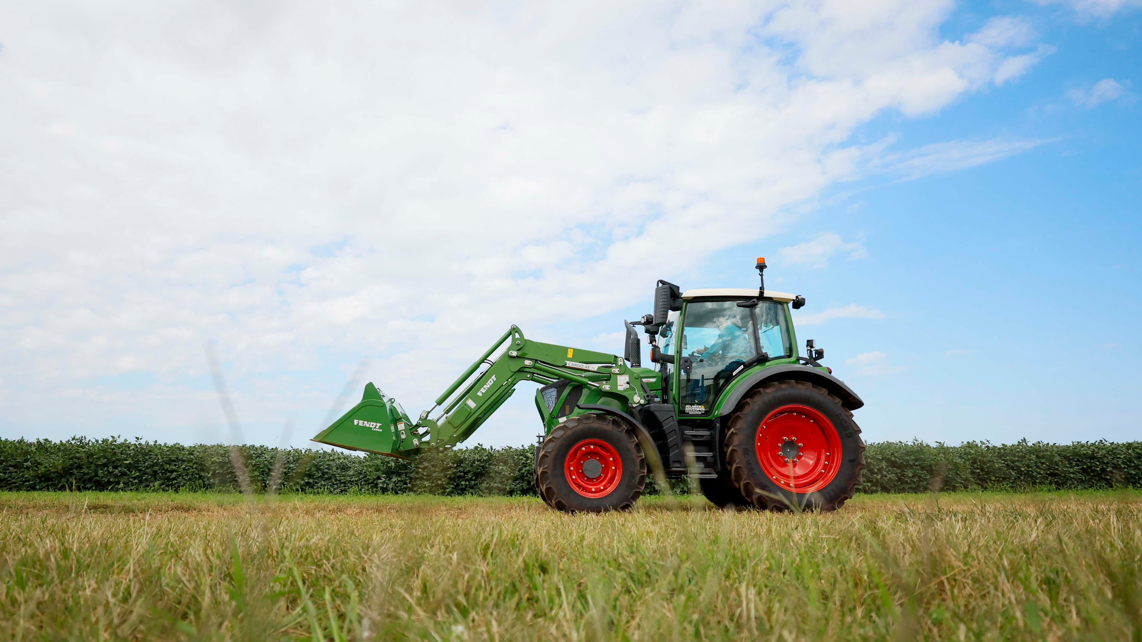 A tractor moves beside a soybean field at Iron Horse Farm with the J. Phil Campbell Sr. Research and Education Center during a demonstration of how they work with precise harvesting using the latest technology from Georgia-based AGCO on Monday, Sept. 8, 2025. AGCO has extended its lease for its Gwinnett County headquarters. (Miguel Martinez/AJC)