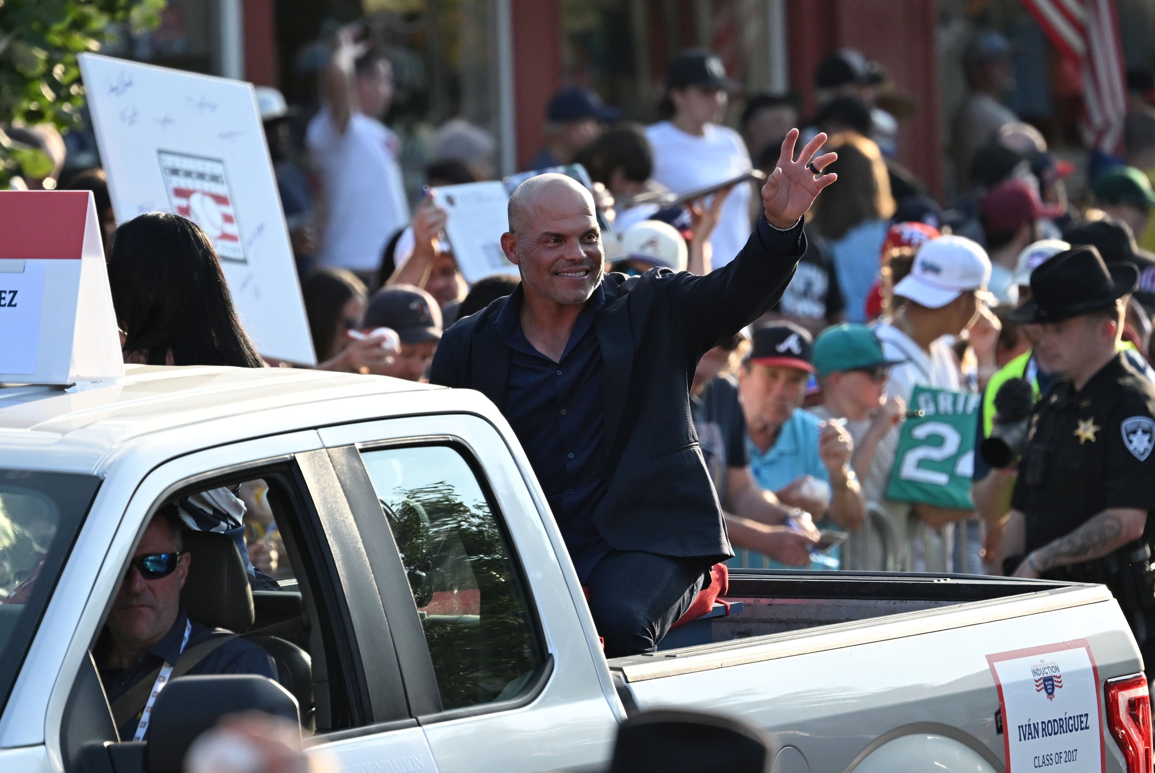 National Baseball Hall of Fame member Ivan Rodriguez waves to spectators from the back of a pickup truck during the Hall of Fame Legends Parade on Saturday, July 25, 2026, in Cooperstown, N.Y. (Hyosub Shin/AJC)