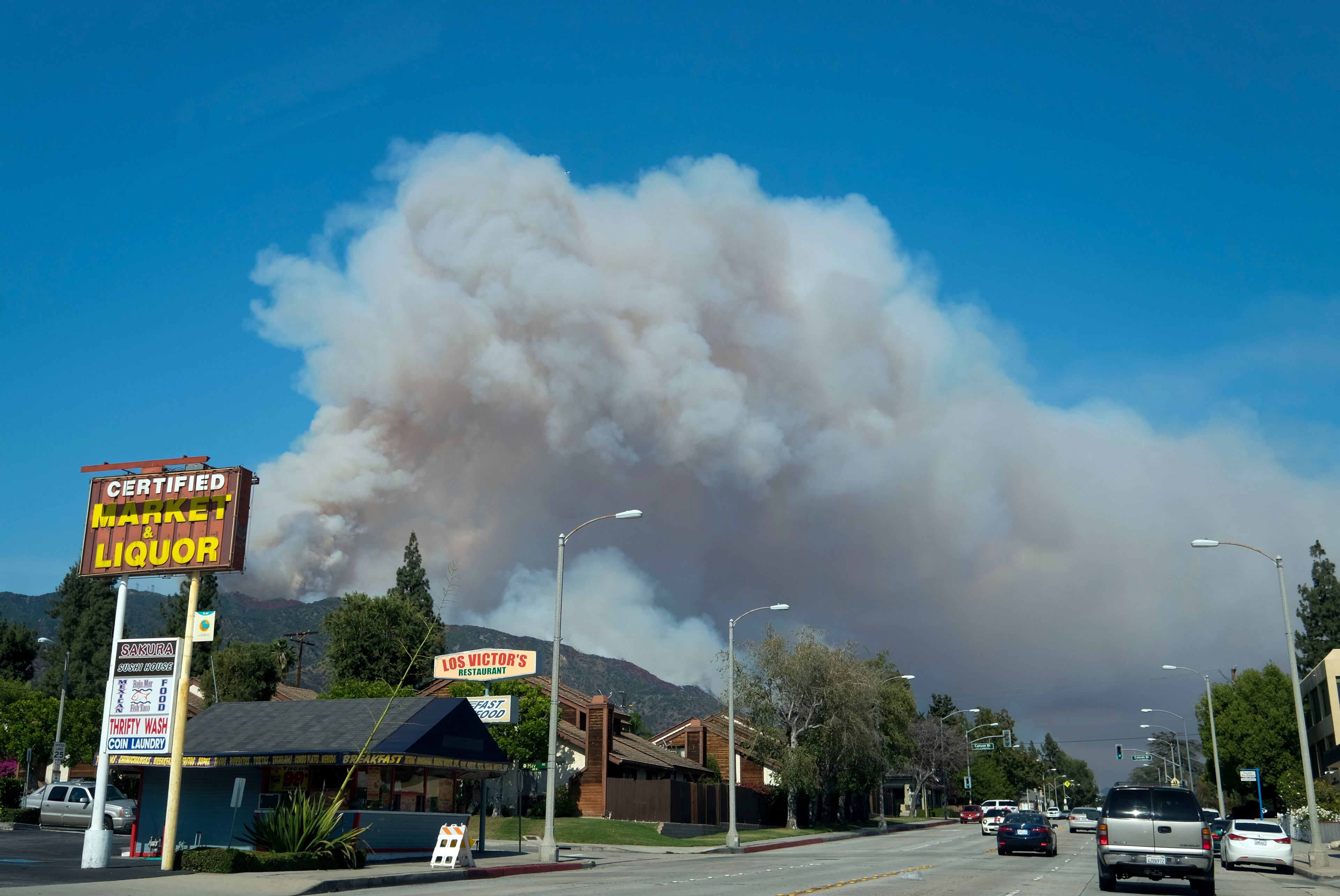 Smoke from wildfires burning in Angeles National Forest fills the sky on Monday, June 20, 2016. (AP Photo/Ringo H.W. Chiu)