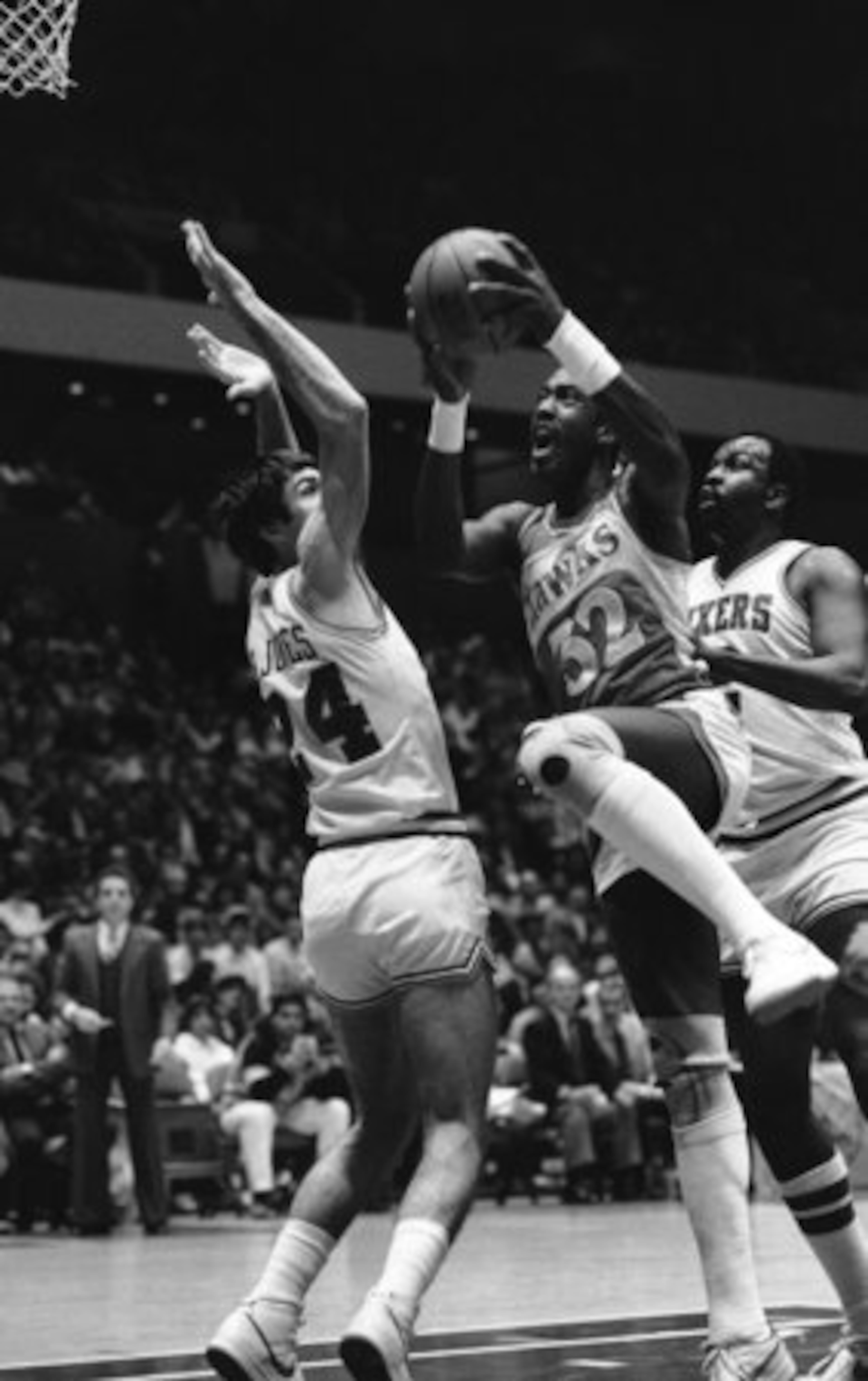 This Dec. 1, 1983 file photo shows Atlanta Hawks' Dan Roundfield, center, going to the basket between Philadelphia 76ers' Bobby Jones, left, and Moses Malone during the first half of an NBA basketball game at the Spectrum in Philadelphia.
