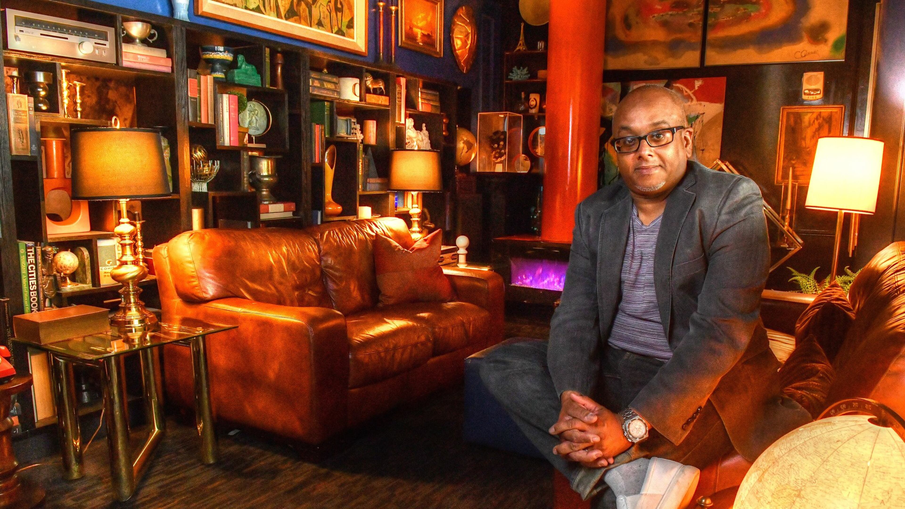 Owner Doug Hines sits in one of the coves in the midcentury decorated the Consulate restaurant in Midtown Atlanta. Hines, a graphic designer by trade who expanded into interior design, purchased items and decorated much of the space himself. Hines is quoted offering critique of "vibe"-driven restaurants in Jordan's story at Eater Atlanta, titled "Good Vibes, Hospitality Not Included."