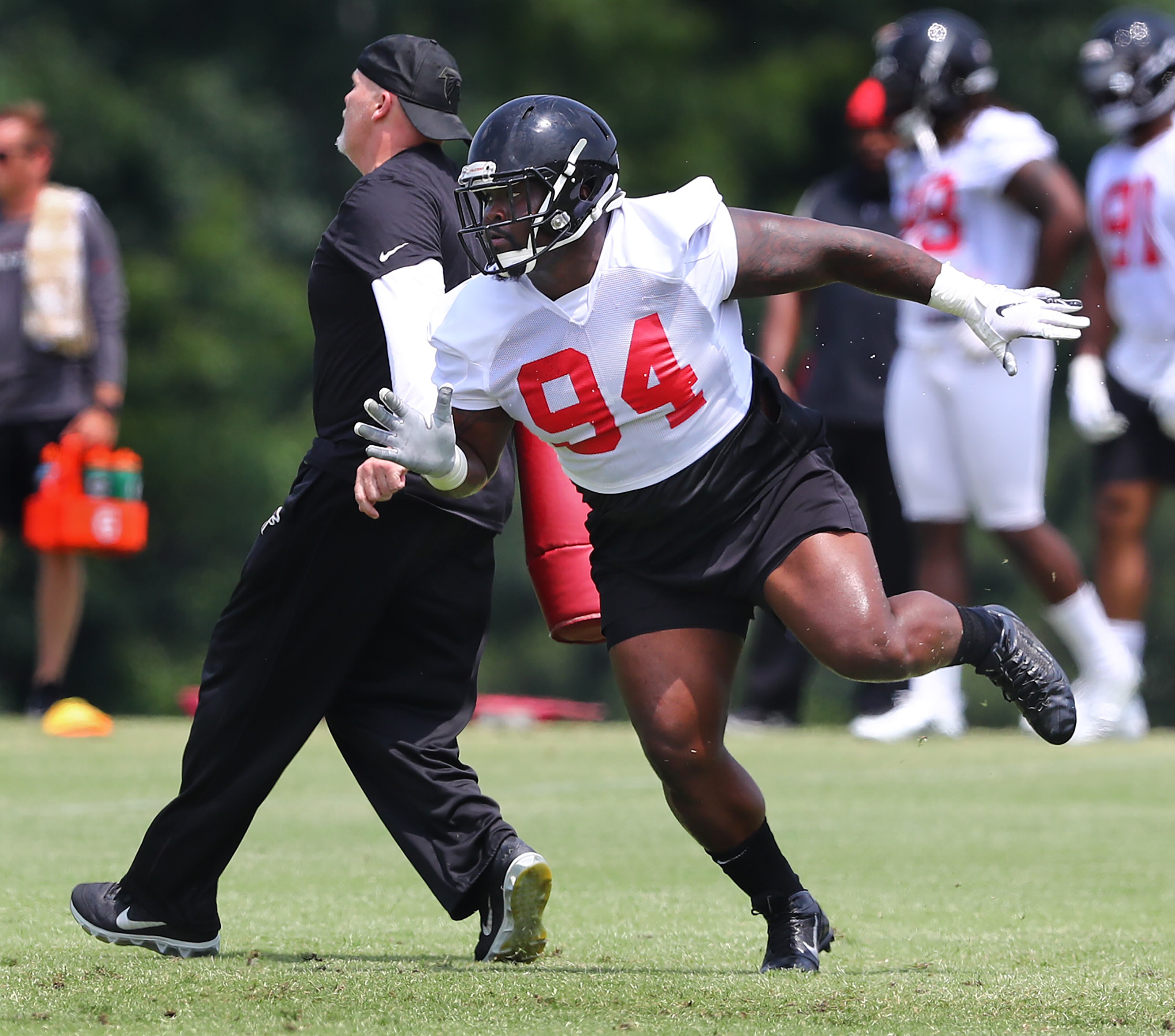Falcons head coach Dan Quinn works on a drill with defensive tackle Deadrin Senat. Curtis Compton/ccompton@ajc.com