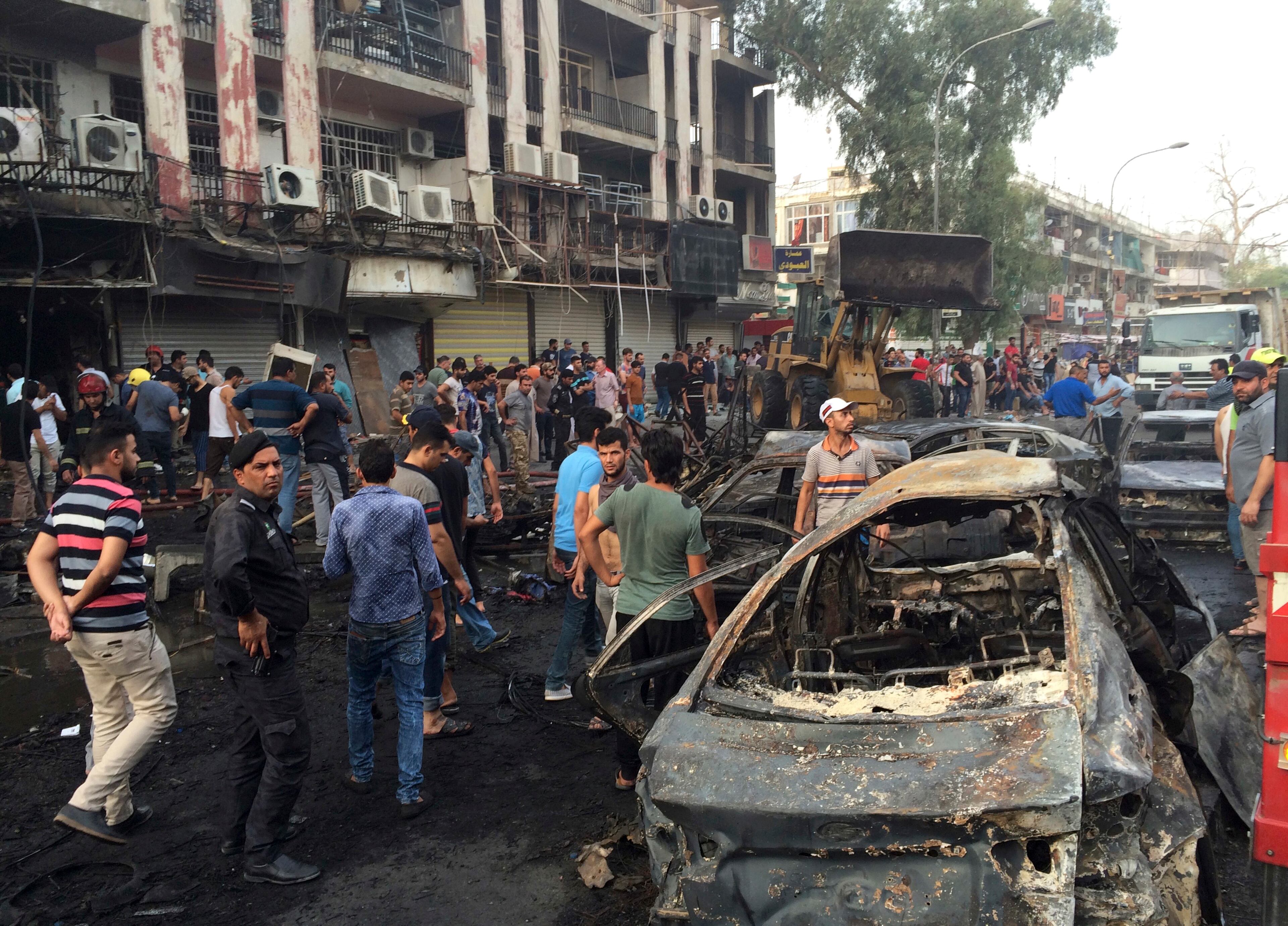 Iraqi security forces and civilians gather at the site after a car bomb at a commercial area in Karada neighborhood, Baghdad, Iraq, Sunday, July 3, 2016. Bombs went off early Sunday in two crowded commercial areas in Baghdad. (AP Photo/Khalid Mohammed)