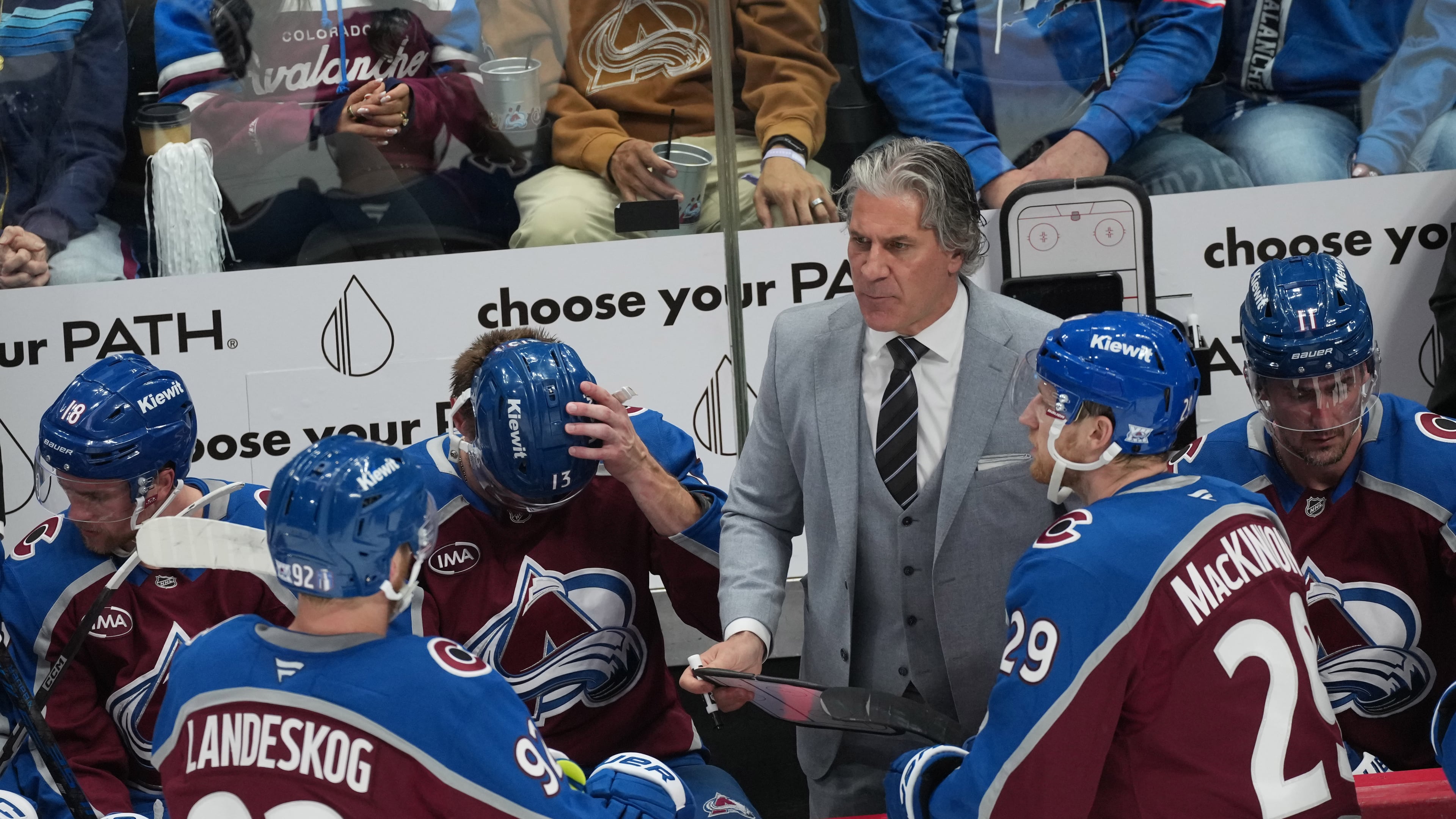 Colorado Avalanche head coach Jared Bednar, back right, confers with center Nathan MacKinnon, front right, and left wing Gabriel Landeskog in the third period of Game 2 of an NHL hockey Stanley Cup second-round playoff series against the Minnesota Wild Tuesday, May 5, 2026, in Denver. (AP Photo/David Zalubowski)