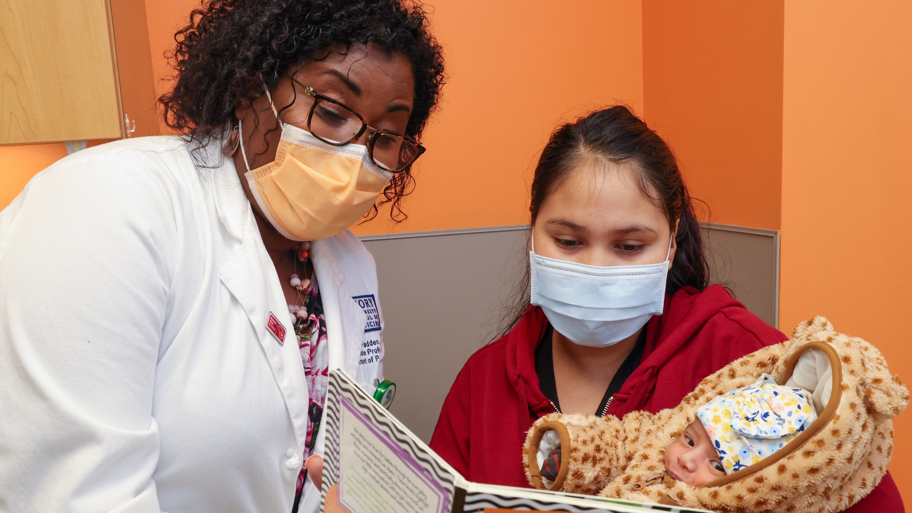 Pediatrician Dr. Terri McFadden encourages Maria Del Rosario to read to her baby, Camila Reyes Espinoza, during a visit to Children's Healthcare of Atlanta at Hughes Spalding. PHIL SKINNER FOR THE ATLANTA JOURNAL-CONSTITUTION