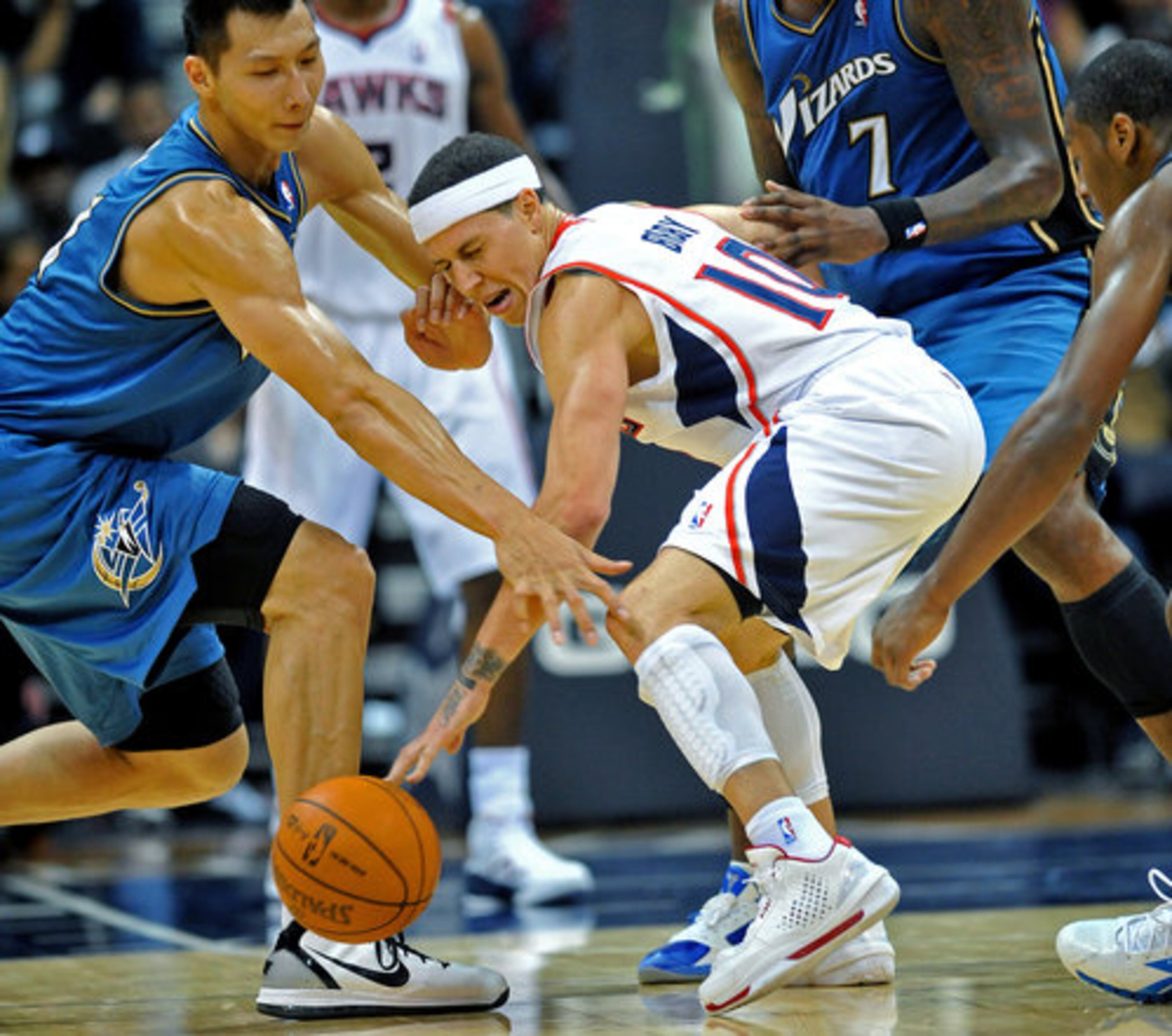 Atlanta Hawks Mike Bibby (10) and Washington Wizards Yi Jianlian (left) go after a loose ball in the second half of the first home game at Philips Arena in Atlanta on Saturday, Oct. 30, 2010. The Hawks beat the Wizards 99 - 95.