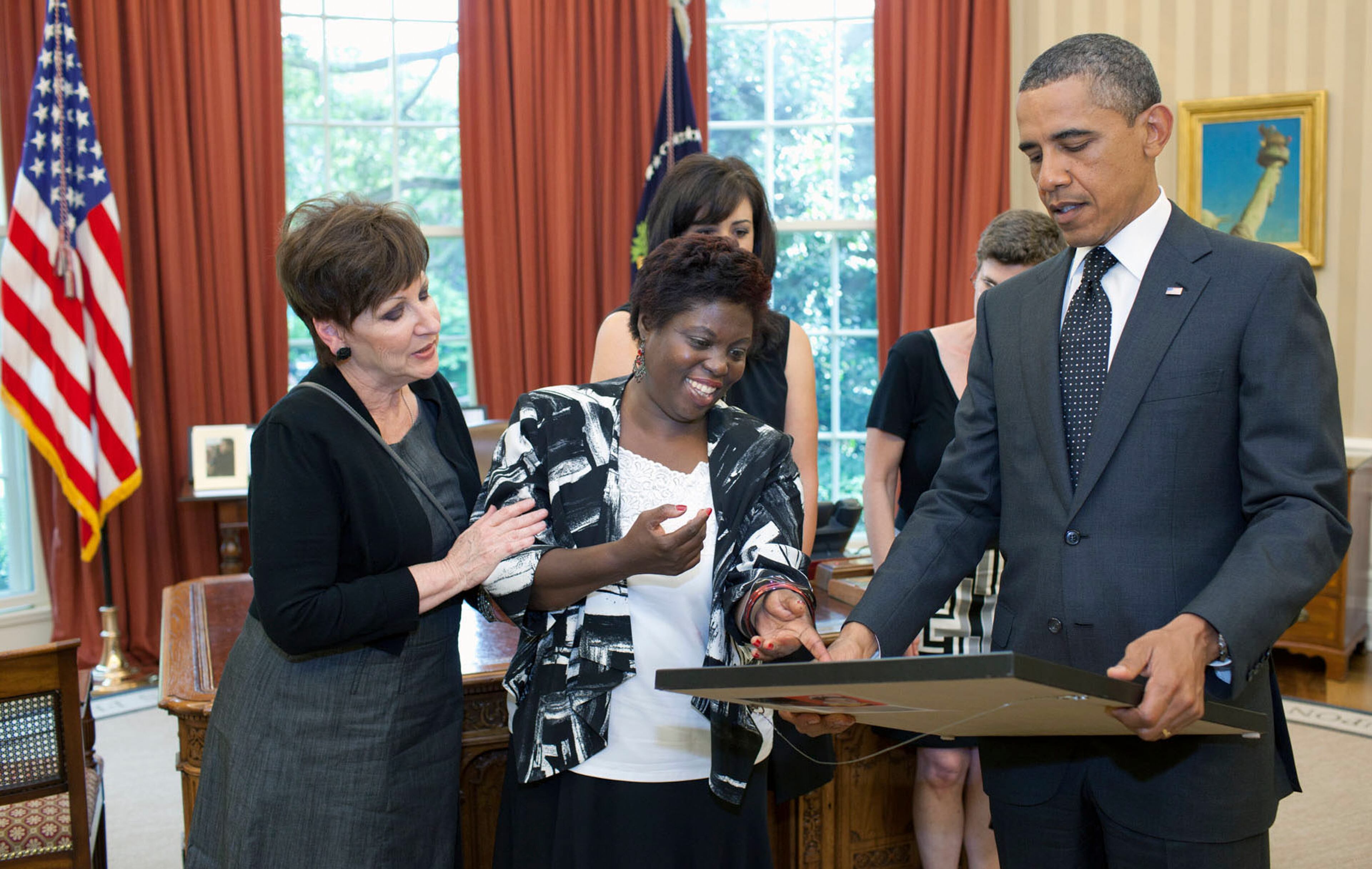 An official White House Photo by Pete Souza shows activist Lois Curtis in 2011 presenting one of her paintings to President Barack Obama. Curtis, who won a landmark civil rights case for people with disabilities, died on Nov. 3, 2022, at her home in Clarkston, Ga. She was 55. (Pete Souza/The White House via The New York Times)