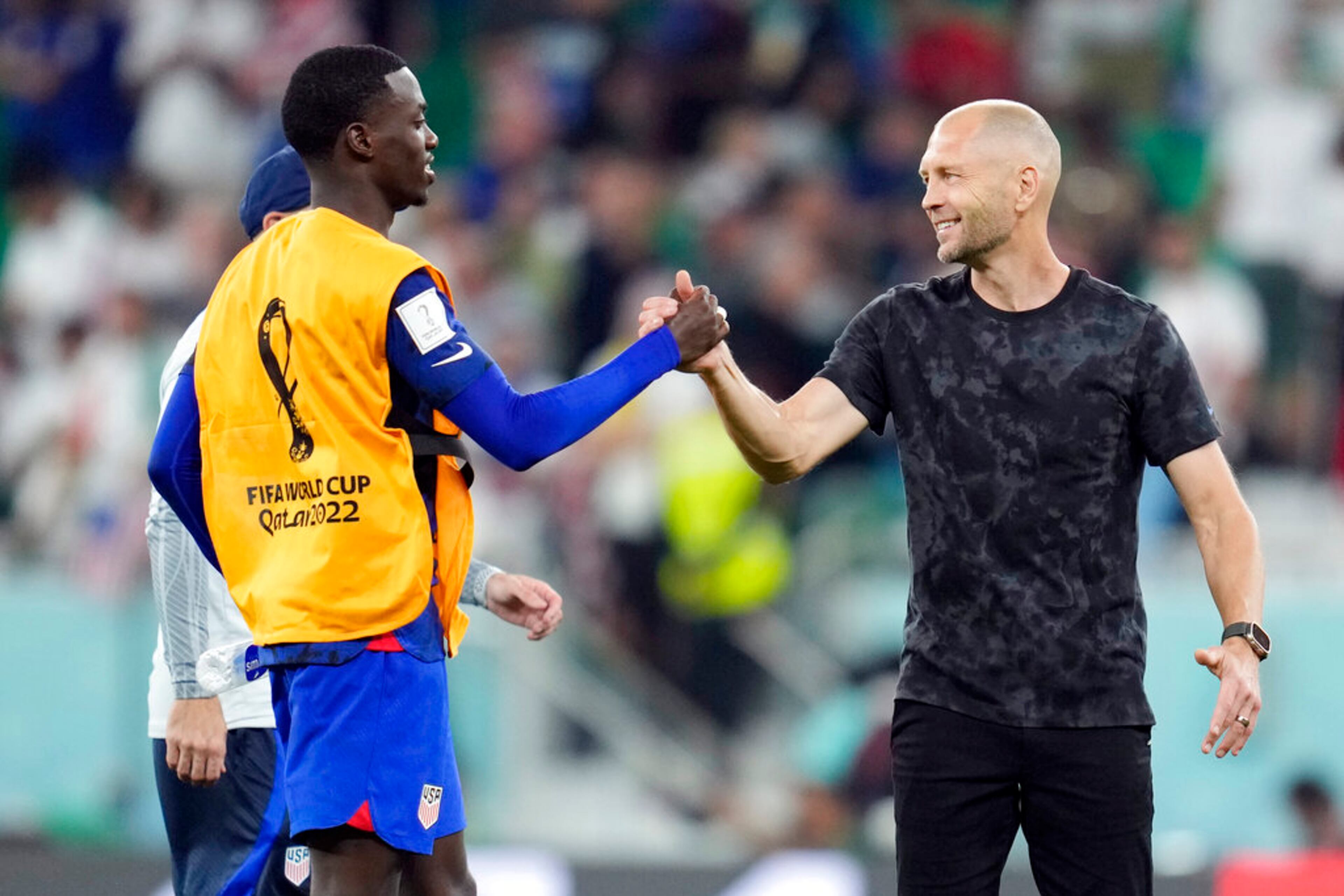 United States' Tim Weah, left, and head coach Gregg Berhalter celebrate after defeating Iran in the World Cup group B soccer match between Iran and the United States at the Al Thumama Stadium in Doha, Qatar, Tuesday, Nov. 29, 2022. (AP Photo/Ashley Landis)
