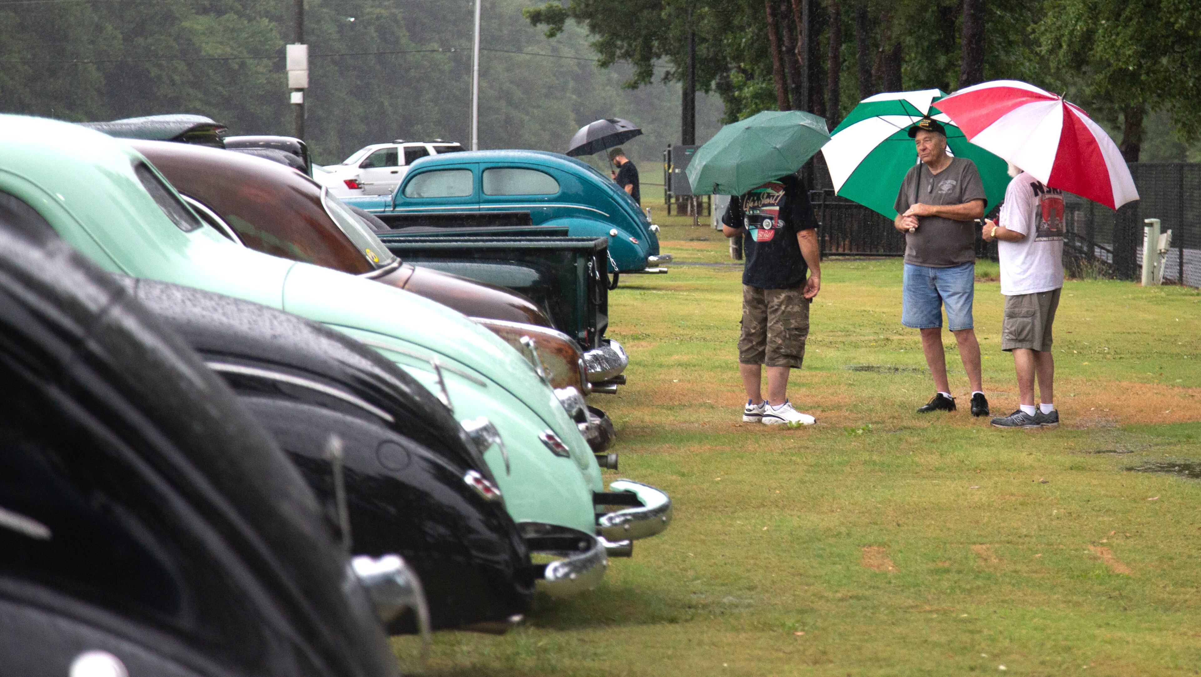 Car enthusiasts try and stay dry during the Creepers Car Club’s 29th annual charity show in Marietta on Sunday, June 8, 2019. STEVE SCHAEFER / SPECIAL TO THE AJC