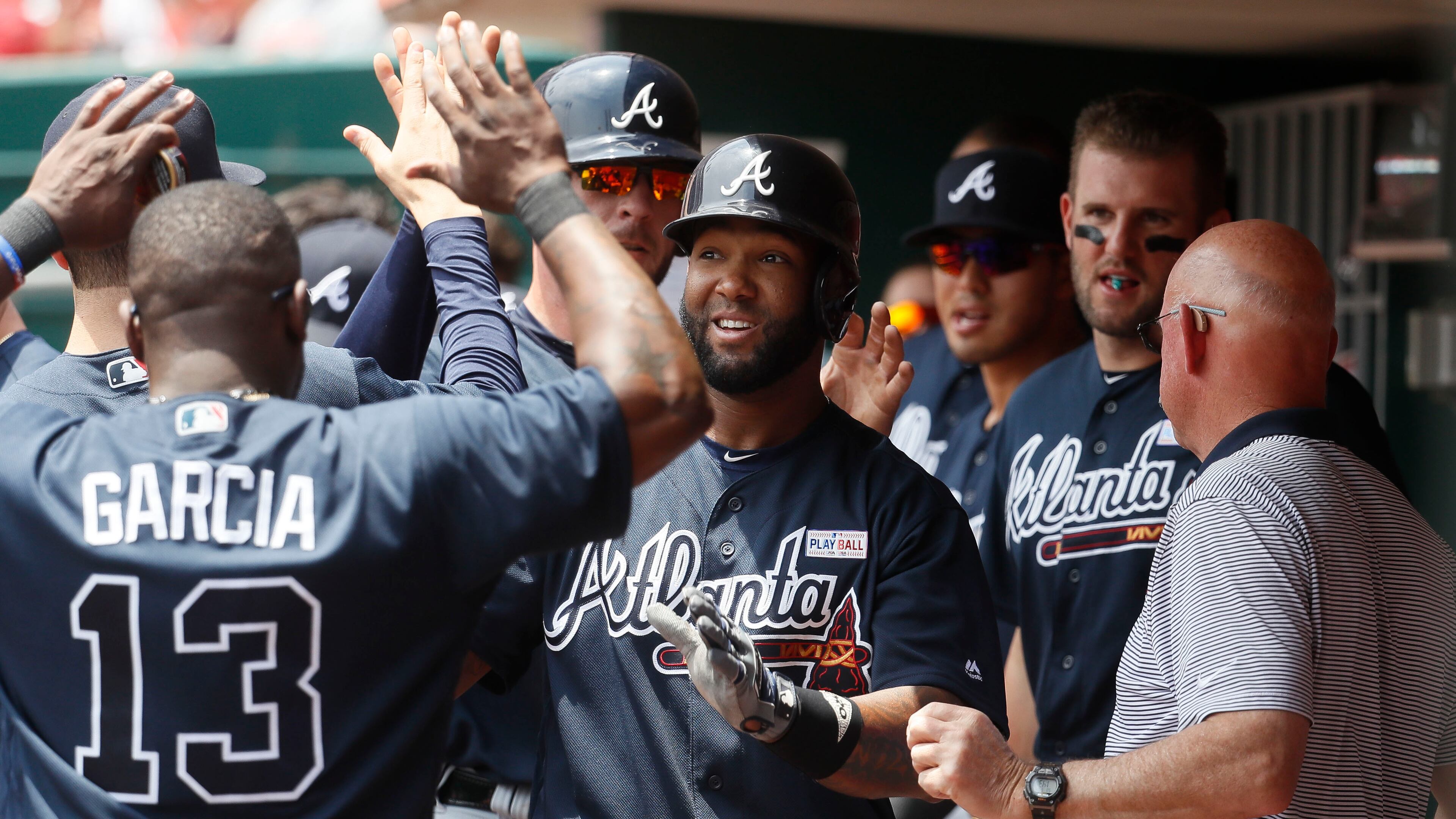 Atlanta Braves' Danny Santana celebrates in the dugout after hitting a two-run home run off Cincinnati Reds starting pitcher Amir Garrett in the second inning of a baseball game, Sunday, June 4, 2017, in Cincinnati. (AP Photo/John Minchillo)