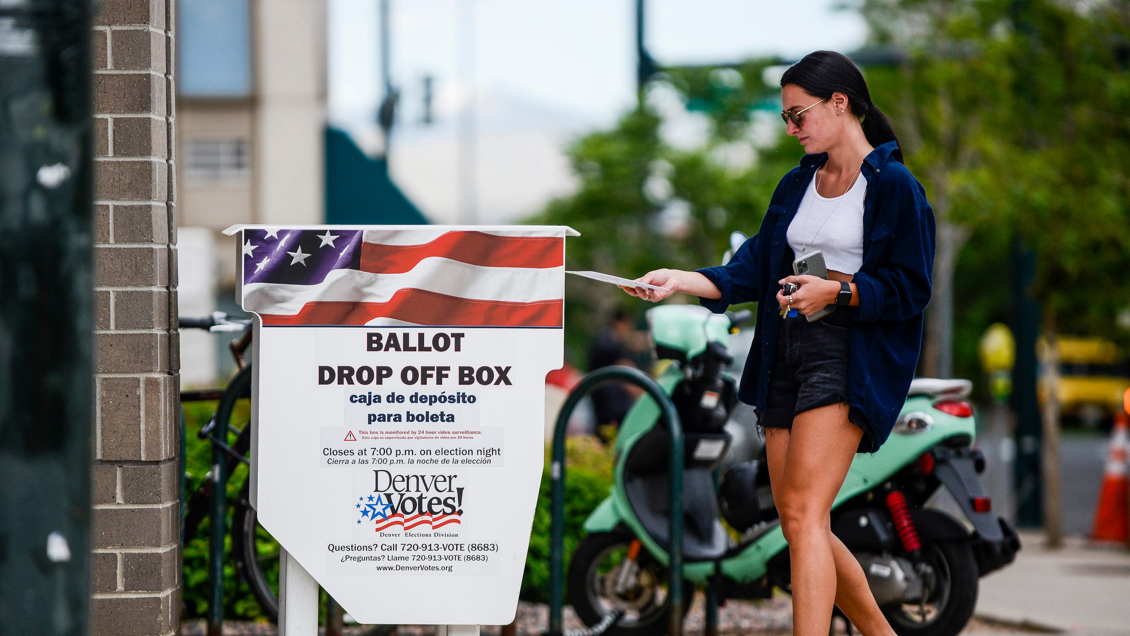 A woman drops off her mail-in ballot outside the Denver Elections Division polling center as she votes in June's Colorado primary. (Michael Ciaglo/Getty Images/TNS)