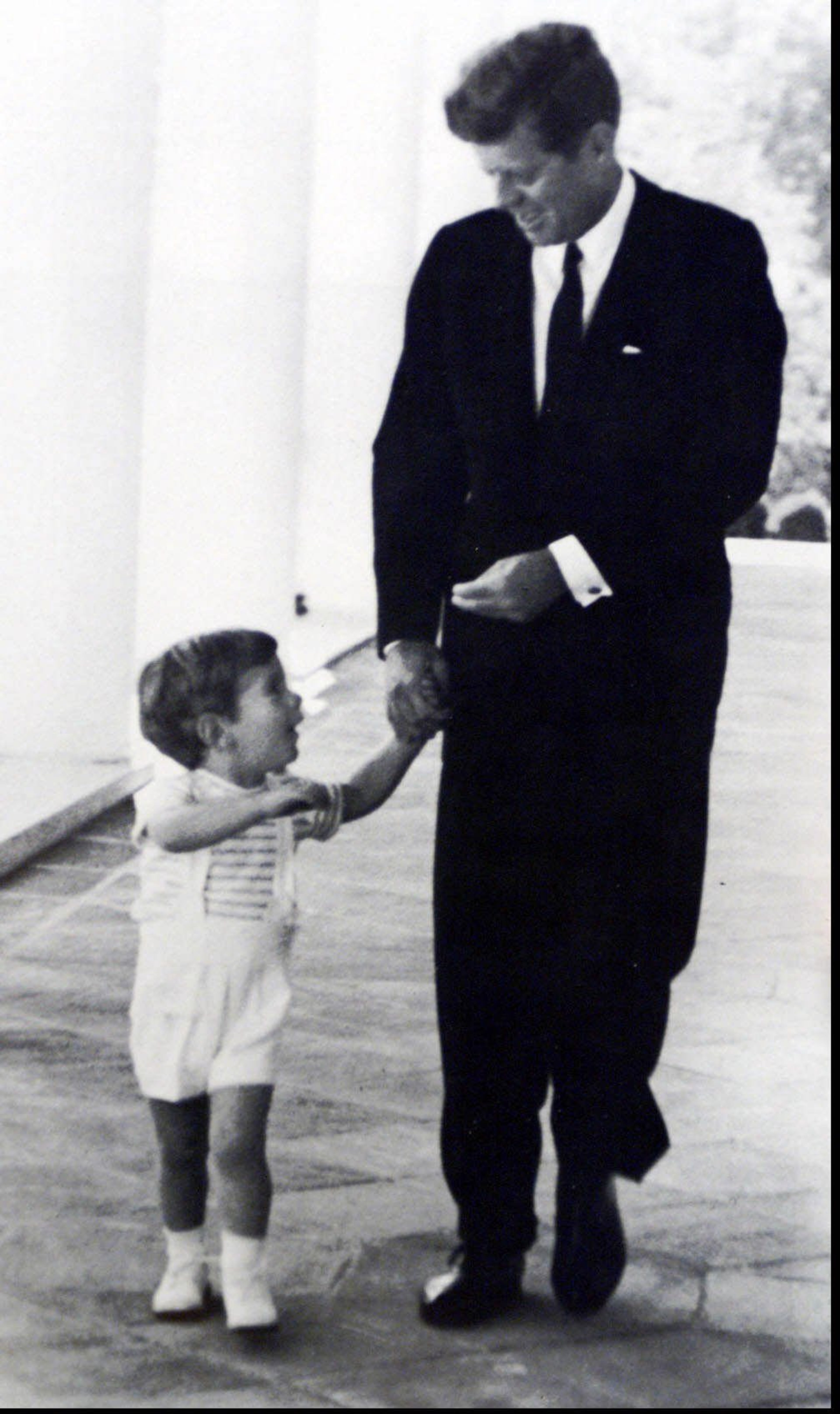 John F. Kennedy, walks with his father at the White House in the summer of 1963. This photo was taken by Cecil Stoughton who was the official photographer for Kennedy. John F. Kennedy, Jr. was missing along with his wife and her sister in a probable airplane accident. - CECIL STOUGHTON