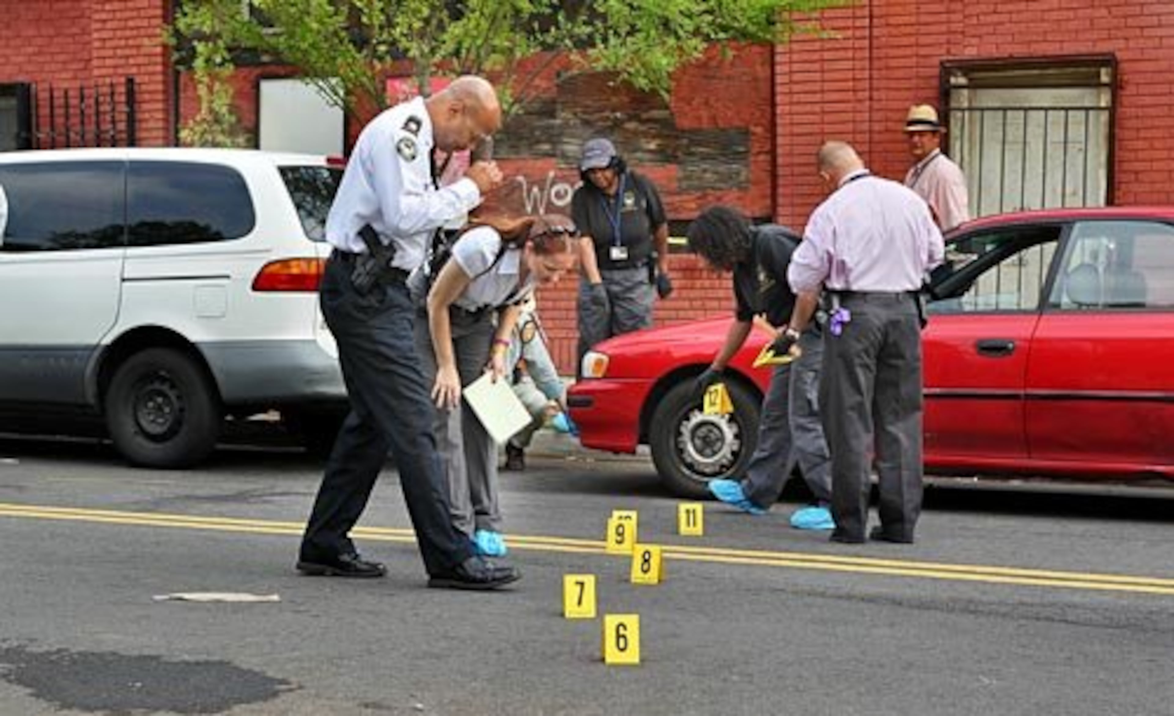 Atlanta police investigators study potential evidence at the stabbing scene from 2010. JOHN SPINK / JSPINK@AJC.COM