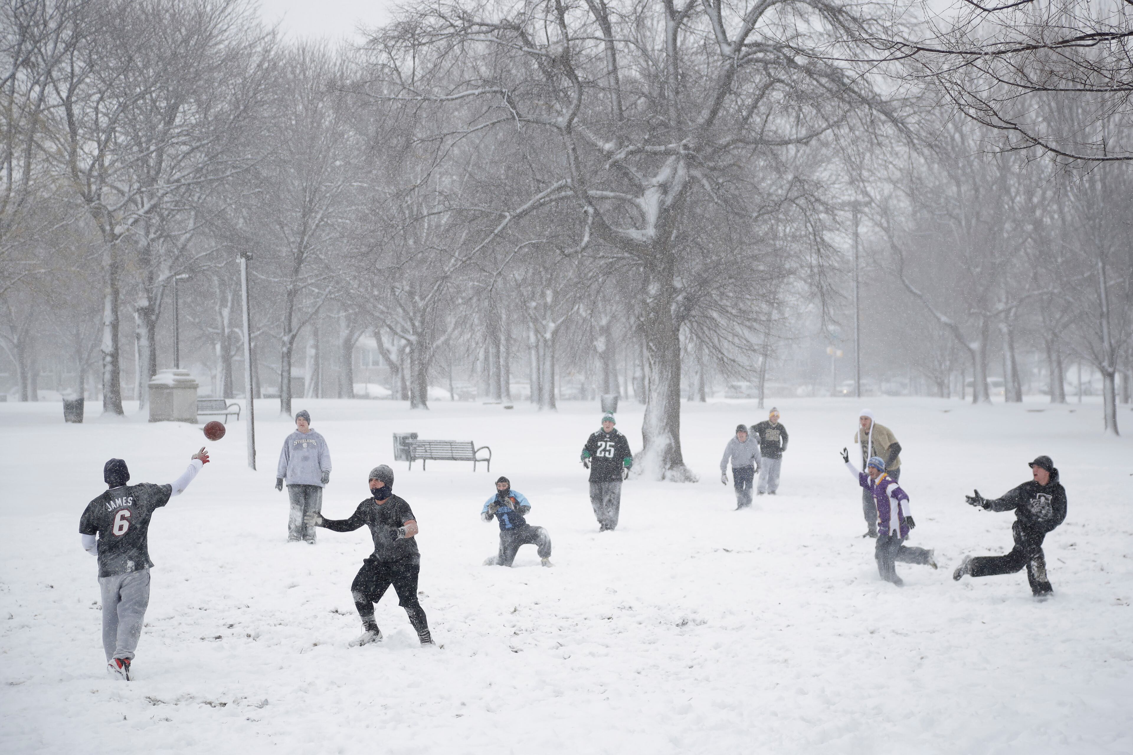 Youths play football in the snow during a winter storm, Thursday, March 5, 2015, at Marconi Plaza in Philadelphia. The Philadelphia area was forecast to receive 5 to 8 inches of snow through Thursday, with lesser amounts to the north and more to the south.(AP Photo/Matt Slocum)