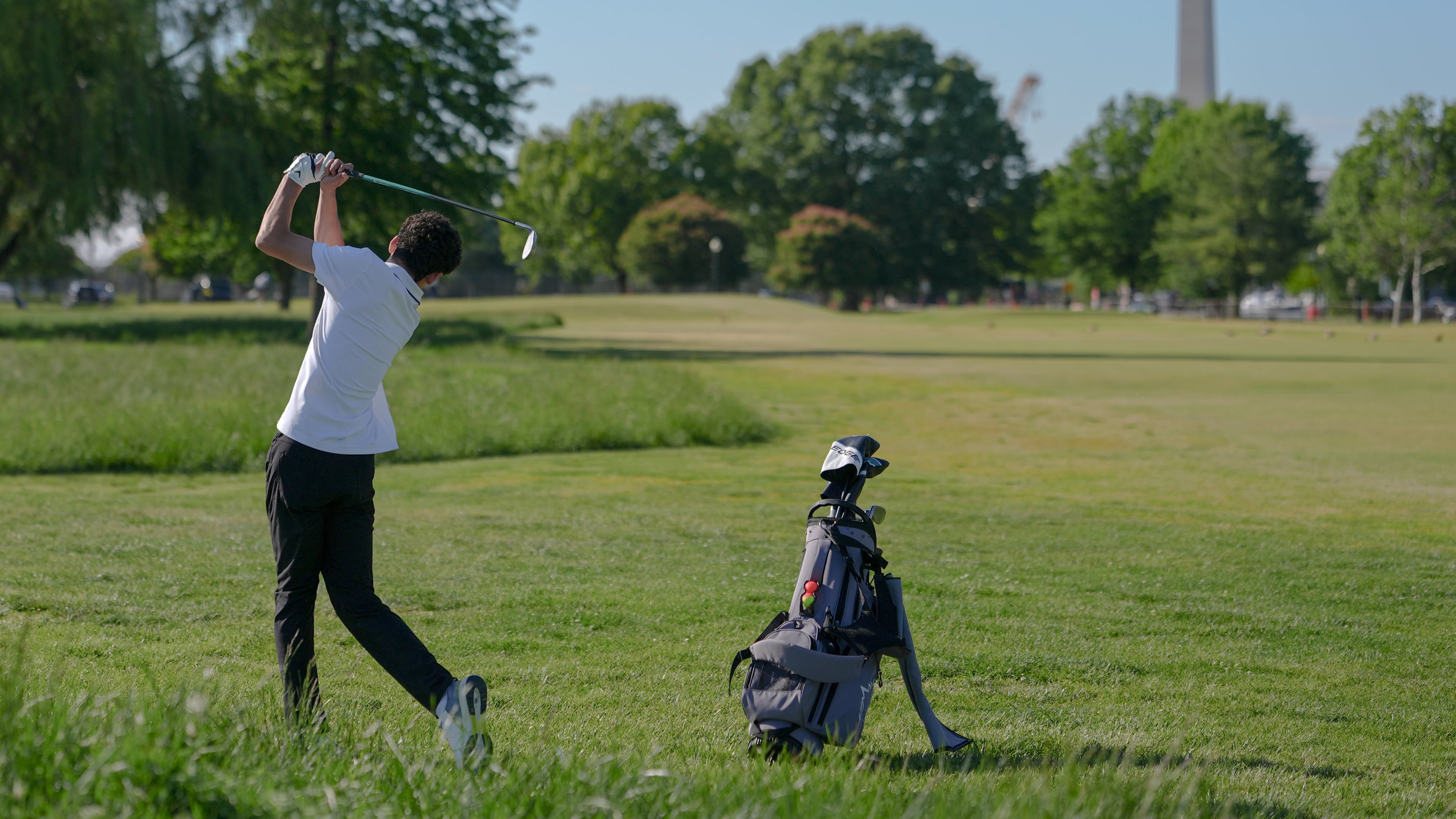 The Washington Monument stands in the background as Roman Sandoli swings at the East Potomac Golf Course, Sunday, May 3, 2026, in Washington. (AP Photo/Julia Demaree Nikhinson)