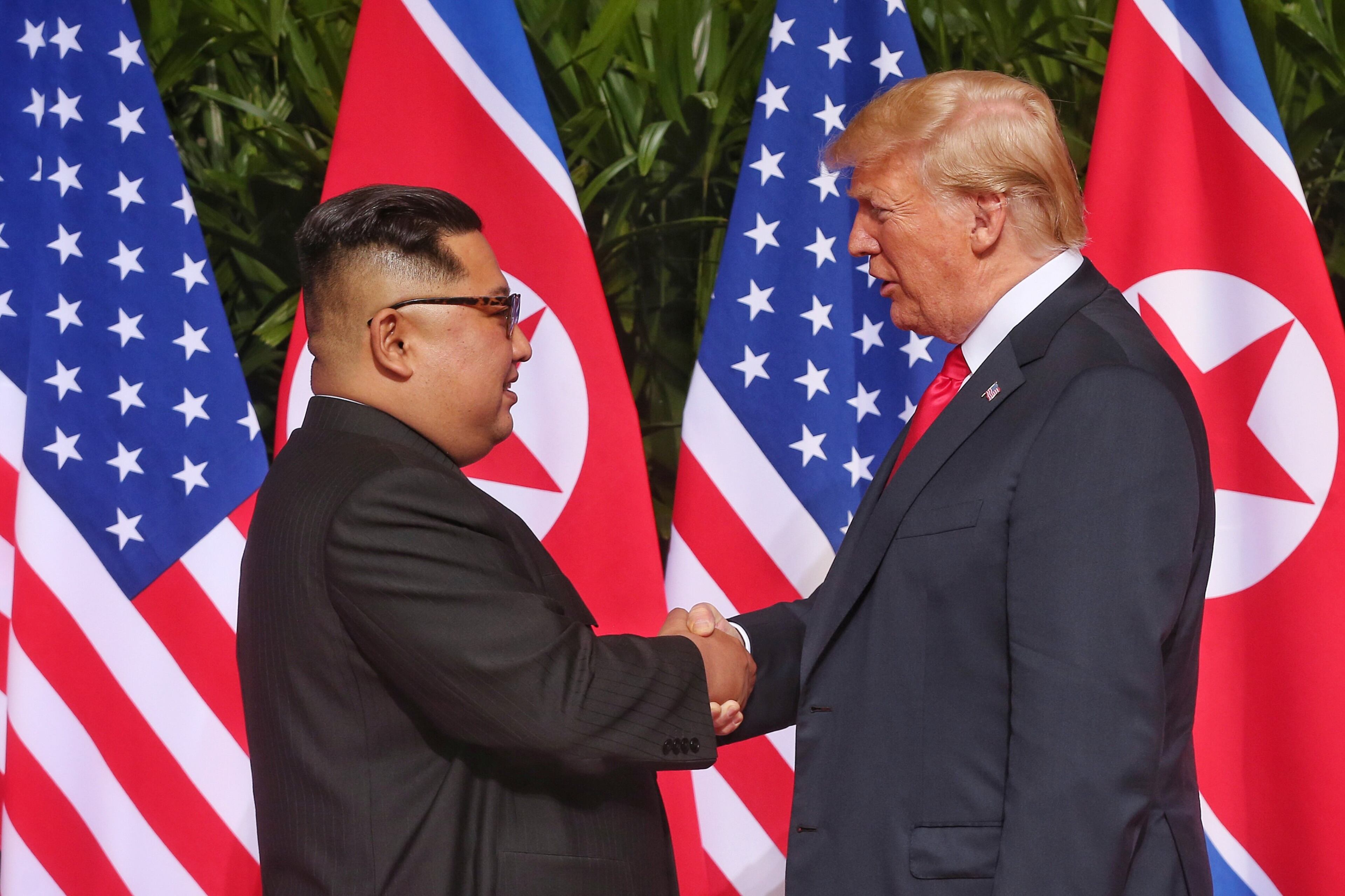SINGAPORE - JUNE 12: In this handout photo, North Korean leader Kim Jong-un (L) shakes hands with U.S. President Donald Trump during their historic U.S.-DPRK summit at the Capella Hotel on Sentosa island on June 12, 2018 in Singapore. U.S. President Trump and North Korean leader Kim Jong-un held the historic meeting between leaders of both countries on Tuesday morning in Singapore, carrying hopes to end decades of hostility and the threat of North Korea's nuclear program. (Photo by Handout/Getty Images)