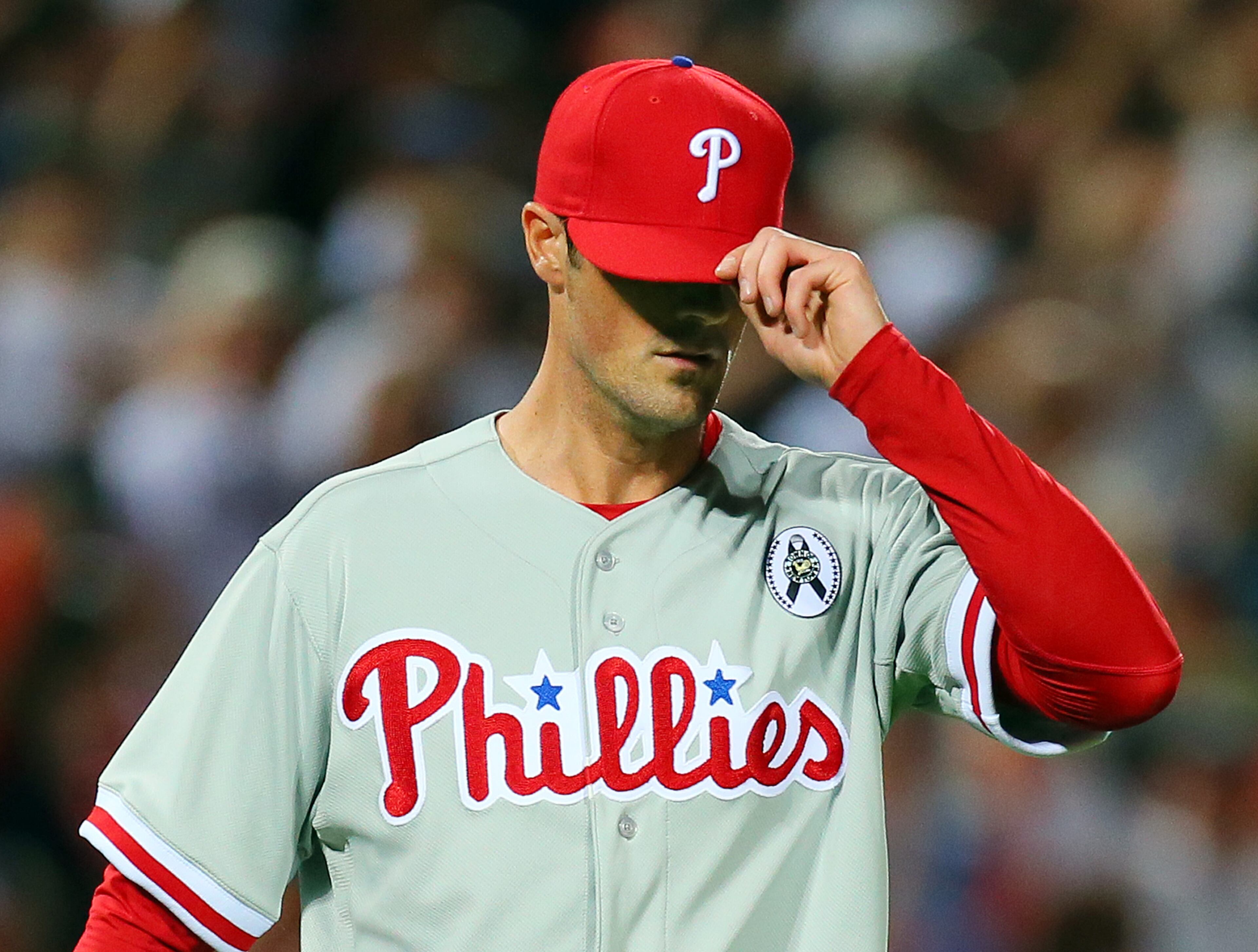 Phillies pitcher Cole Hamels covers his face giving up a solo home run to Braves Justin Upton in the fifth inning.