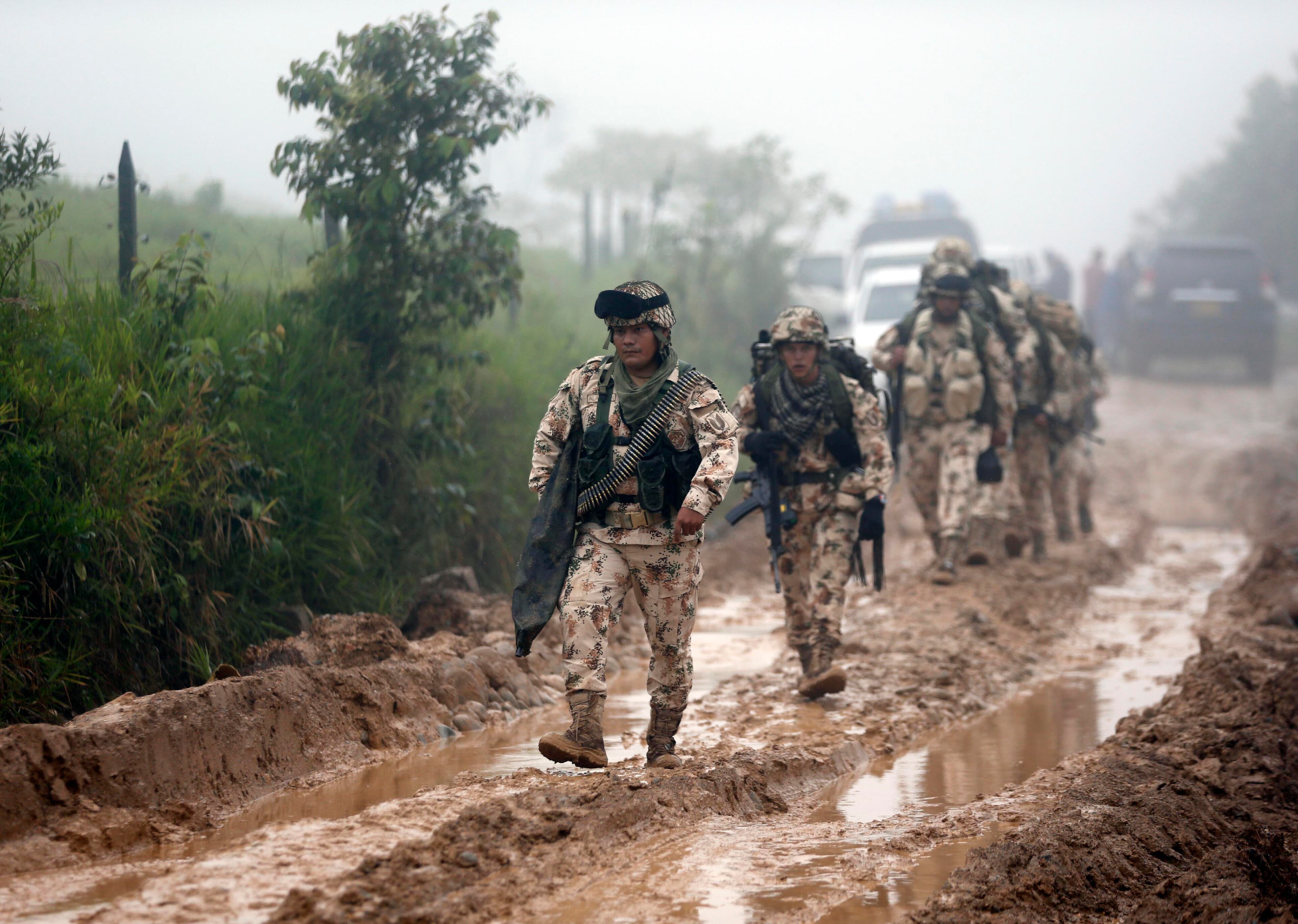 Army soldiers arrive to guard the Mariana Paez demobilization zone, one of many rural camps where FARC rebel fighters are making their transition to civilian life, one day ahead of an event with President Juan Manuel Santos in Buenavista, Colombia, Monday, June 26, 2017. On Tuesday, Colombia's president will meet the FARCÕs top commander Timochenko at this camp to commemorate the completion of the disarmament process. (AP Photo/Fernando Vergara)