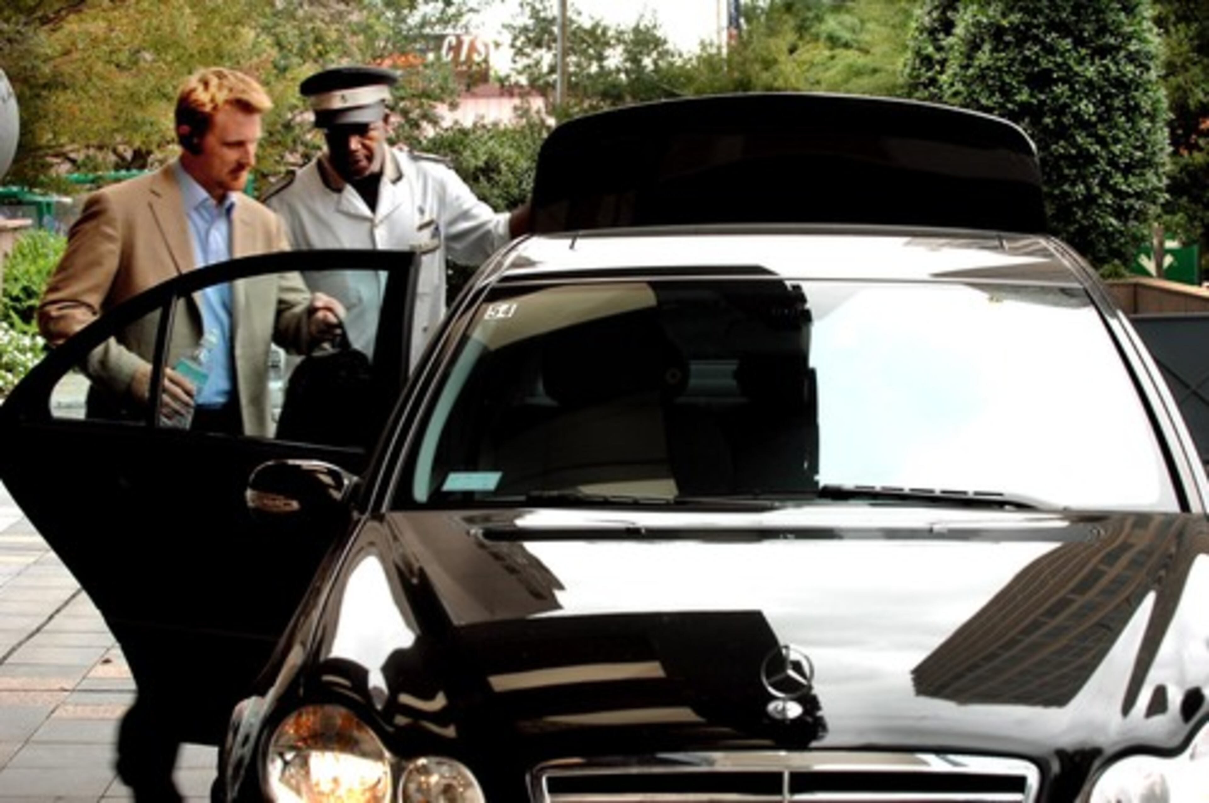 Doorman Fredd Henderson helps a guest into a departing limo at the Four Seasons.