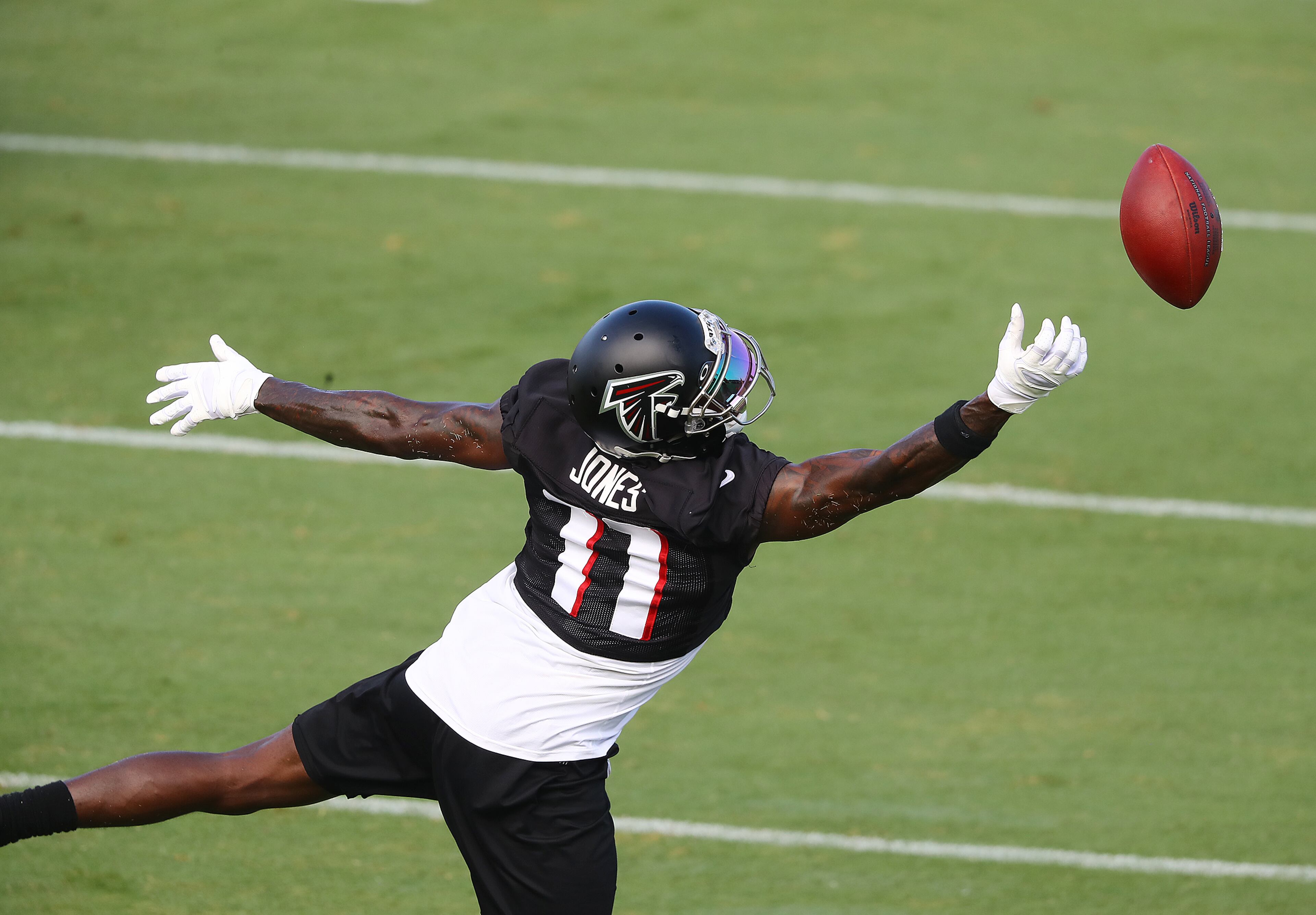 Falcons wide receiver Julio Jones goes up for a tipped pass from Matt Ryan during practice Wednesday, Aug.19, 2020, in Flowery Branch.