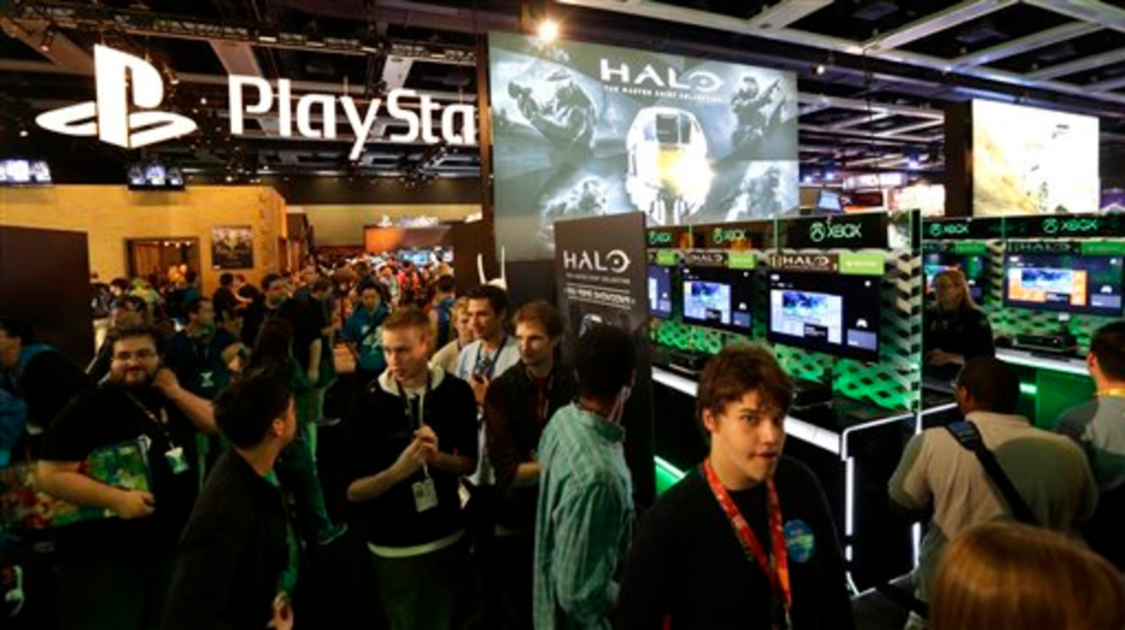 Attendees at the Penny Arcade Expo, a fan-centric celebration of gaming in Seattle, walk past adjoining displays from gaming giants Sony PlayStation and Microsoft's Xbox One, Friday, Aug. 29, 2014. The event is expected to be attended by roughly 85,000 gamers and will include concerts, game tournaments and previews of upcoming titles. (AP Photo/Ted S. Warren)