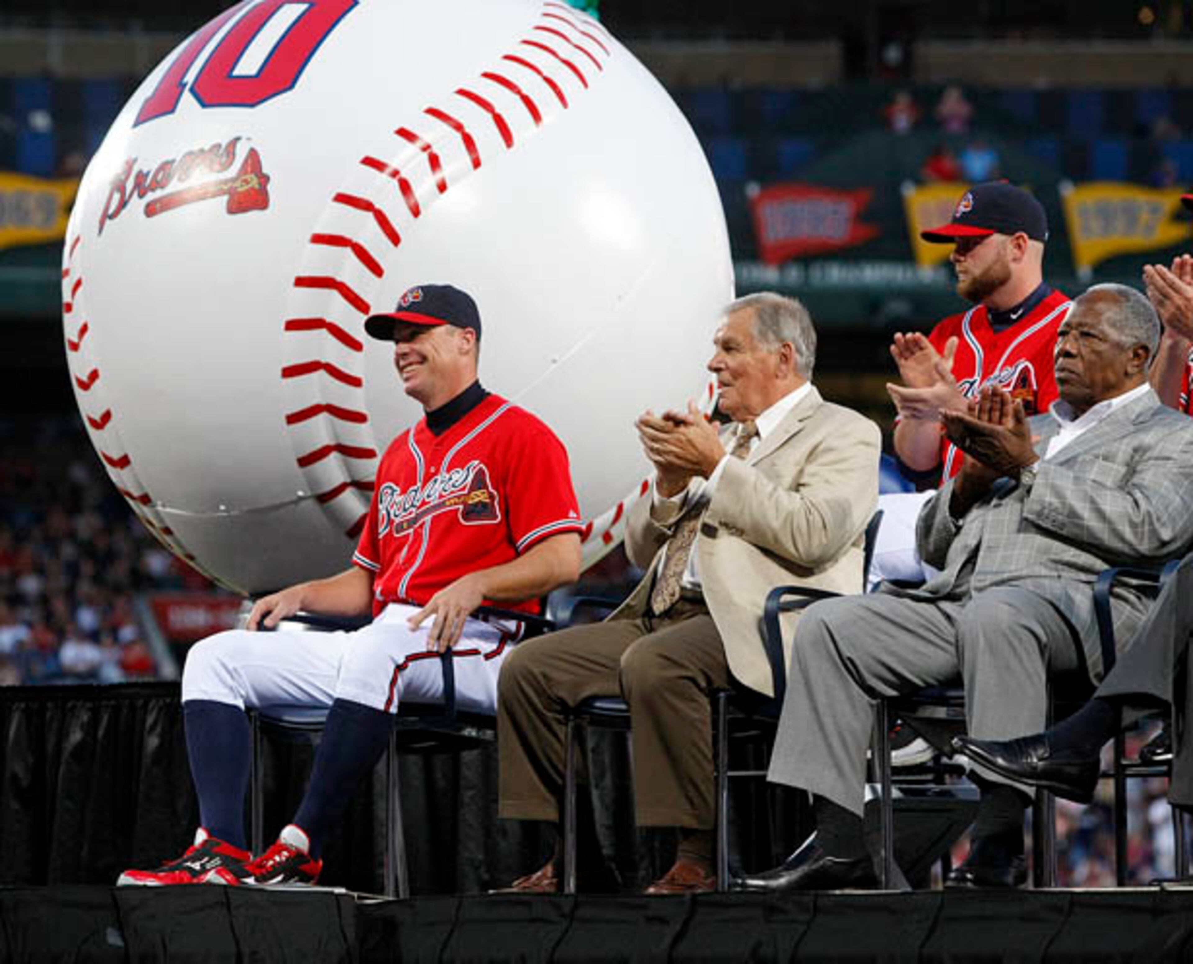 Chipper Jones is all smiles as he receives applause from former manager Bobby Cox (from left), teammate Brian McCann and Braves legend Hank Aaron.