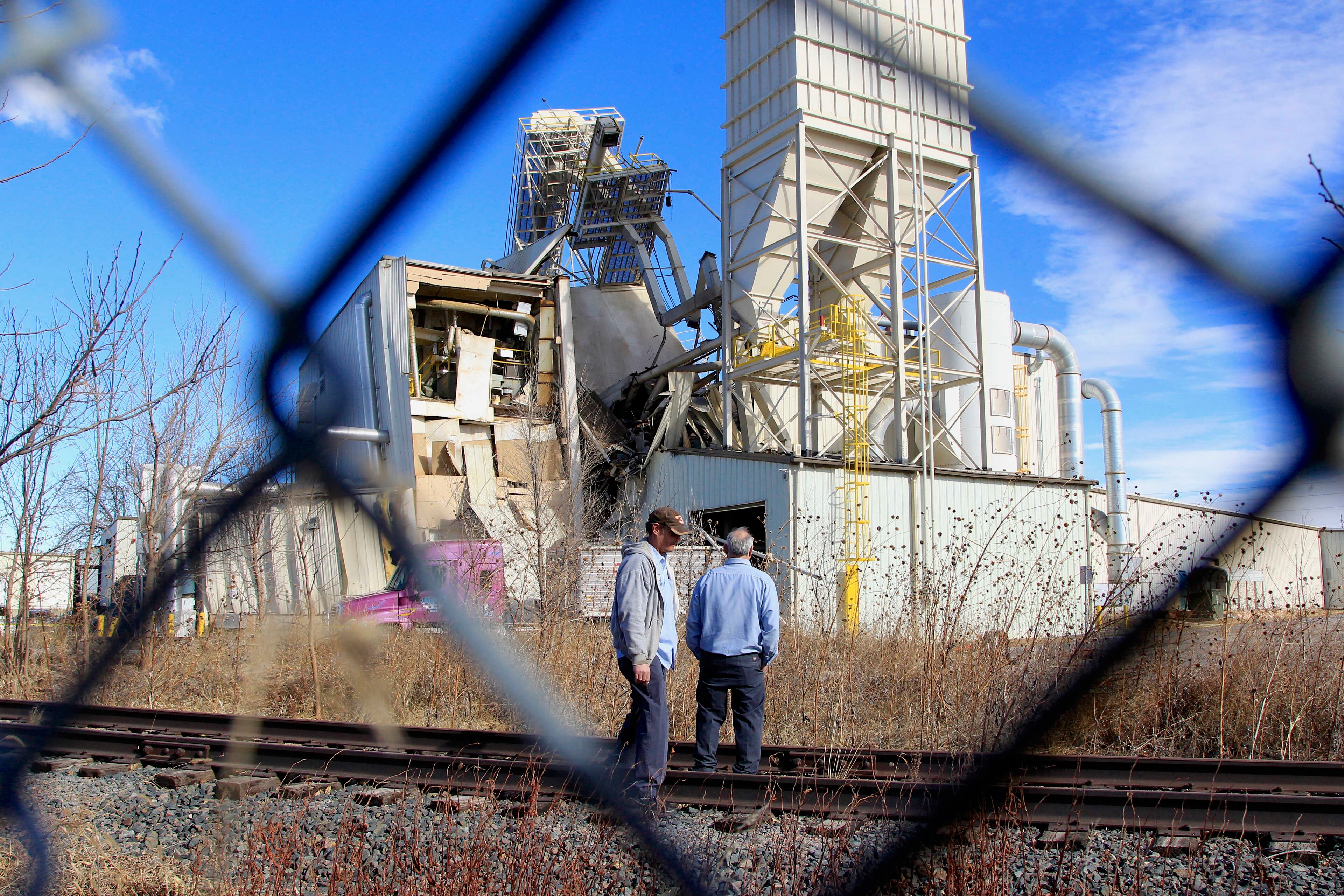 Two unidentified people with ties to the International Nutrition plant in Omaha, Neb., stand Monday, Jan. 20, 2014, outside the plant where a fire and explosion took place . "It's very extreme conditions" inside the plant now, Interim Omaha Fire Chief Bernie Kanger said. "There is significant structural damage inside."