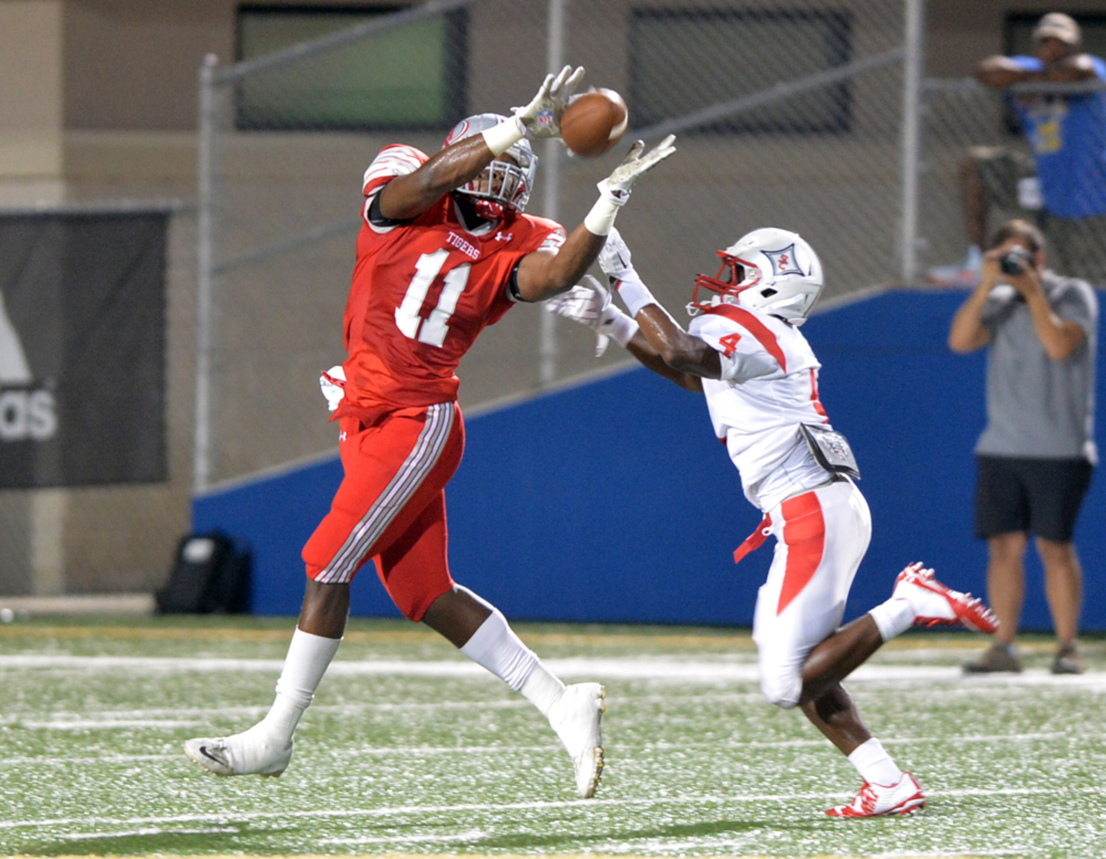 HS FOOTBALL SEASON STARTS--AUGUST 22, 2014 POWDER SPRINGS Archer wide receiver Kyle Davis catches an 80-yard pass for a touchdown over Sandy Creek defender #4 Brian Miller during action in the first half in the second game of the 2014 Corky Kell Classic between the Sandy Creek Patriots and the Archer Tigers at McEachern HS Walter H. Cantrell Stadium Friday, August 22, 2014. KENT D. JOHNSON / KDJOHNSON@AJC.COM