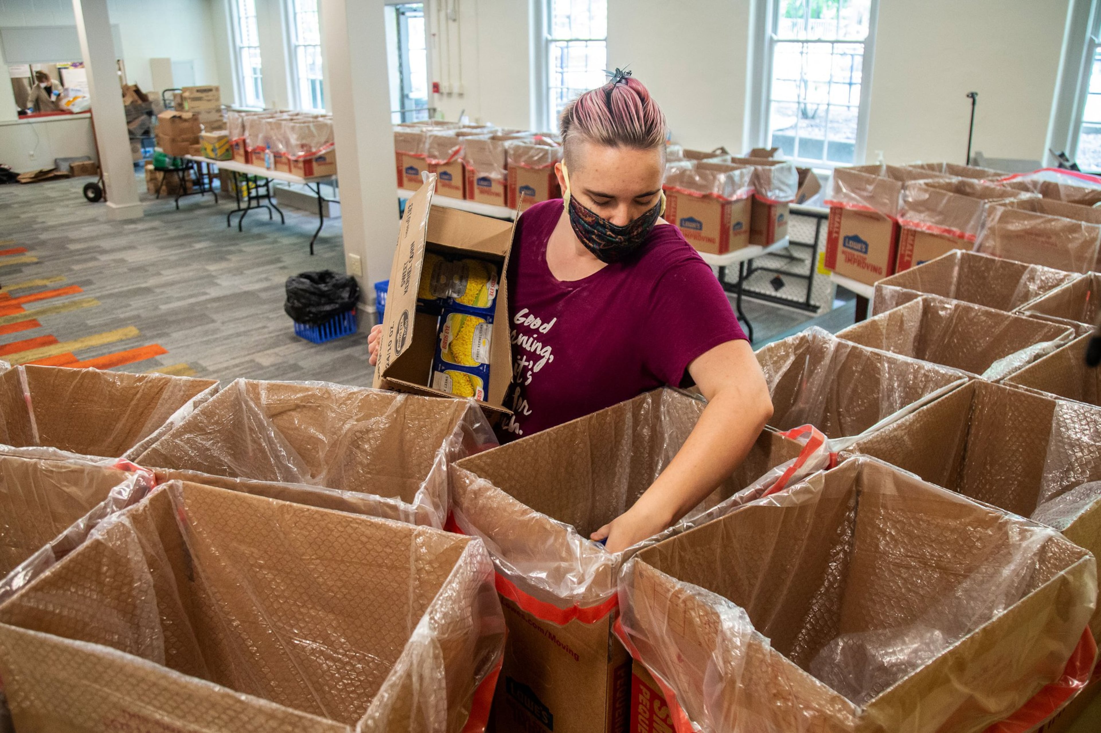 Food 4 LIFE volunteer Jessica Struempf packs up some of the 100 boxes of groceries in preparation for their delivery in Atlanta. STEVE SCHAEFER / SPECIAL TO THE AJC