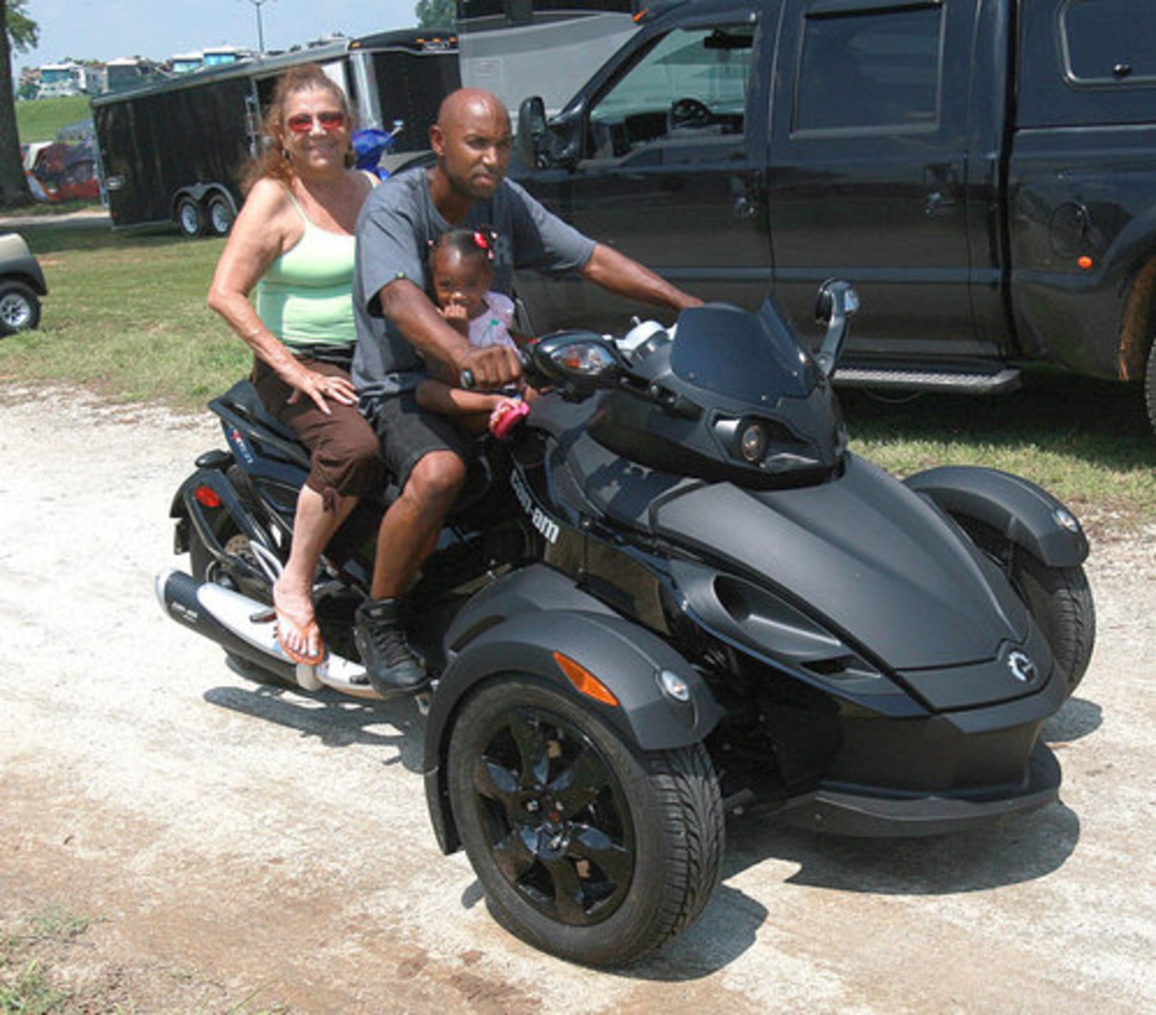 World champion bike racer Rickey Gadson rides with his his mother, Vicky Gadson, and 2-year-old daughter, Laila, around the campgrounds at National Bikers Roundup.