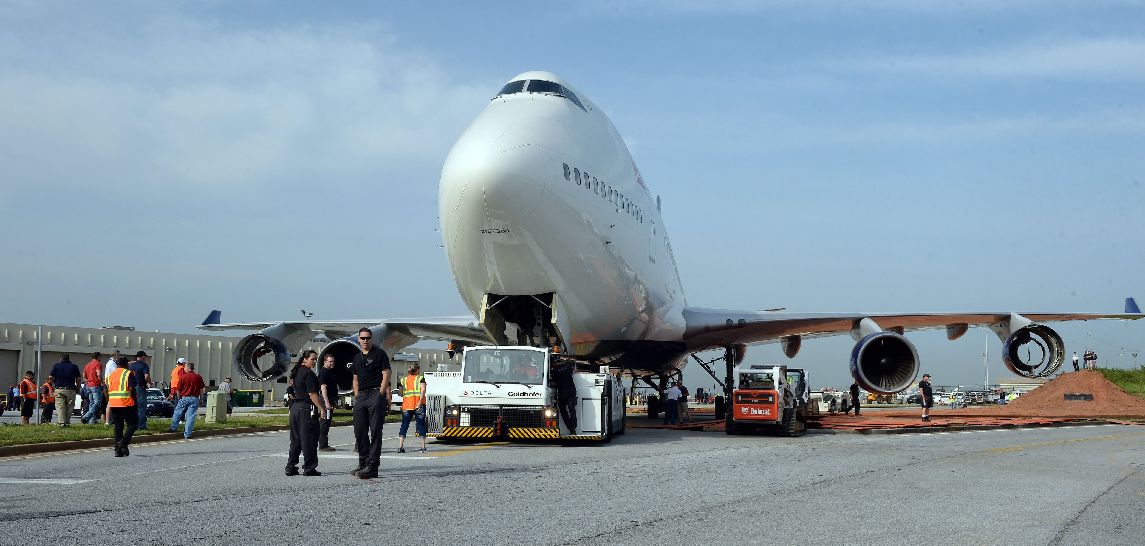 APRIL 30, 2016 ATLANTA Bobcat loaders construct a steel ramp as crews move a retired Boeing 747-400 to the Delta Flight museum Saturday, April 30, 2016. Delta Air Lines Ship 6301 made its final journey to Delta’s Atlanta world headquarters campus in preparation for the Delta Flight Museum's latest exhibit featuring the retired aircraft. On September 9, 2015, Delta retired Ship 6301, the first Boeing 747-400 aircraft manufactured for a commercial airline, after its final flight from Honolulu to Atlanta. KENT D. JOHNSON /kdjohnson@ajc.com #delta747experience